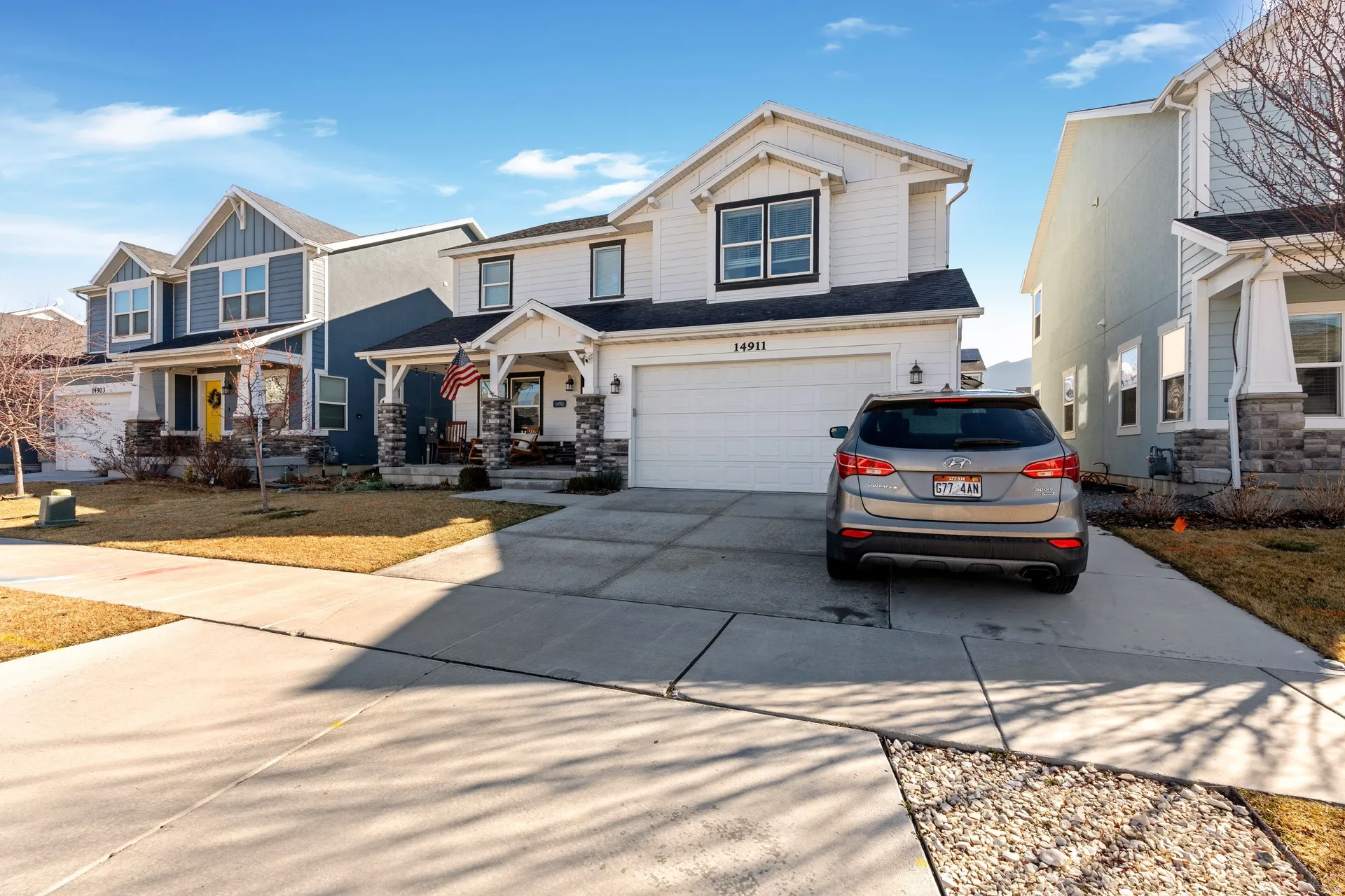 Craftsman house with board and batten siding, covered porch, driveway, and an attached garage