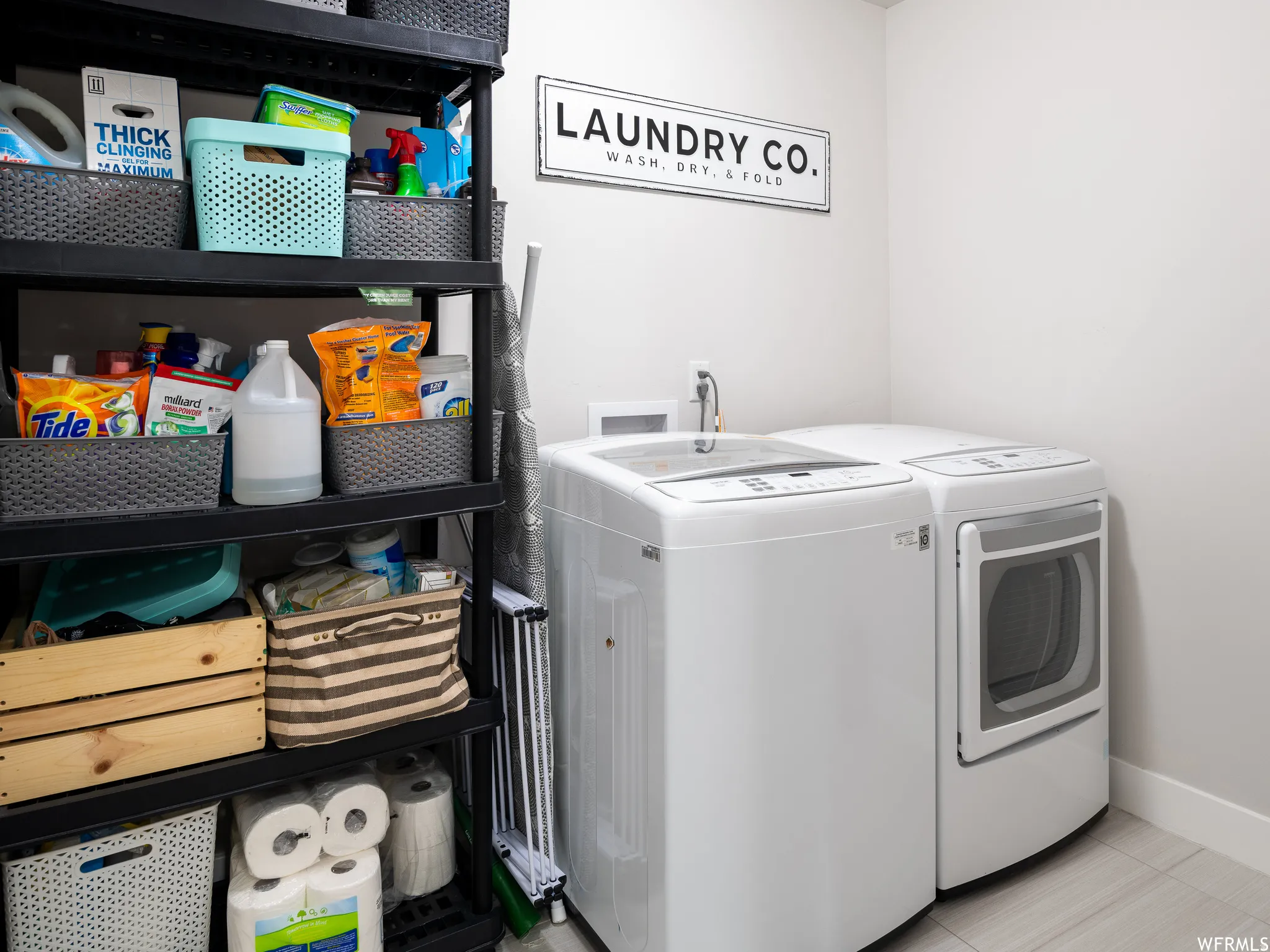 Laundry room with separate washer and dryer and light tile patterned flooring