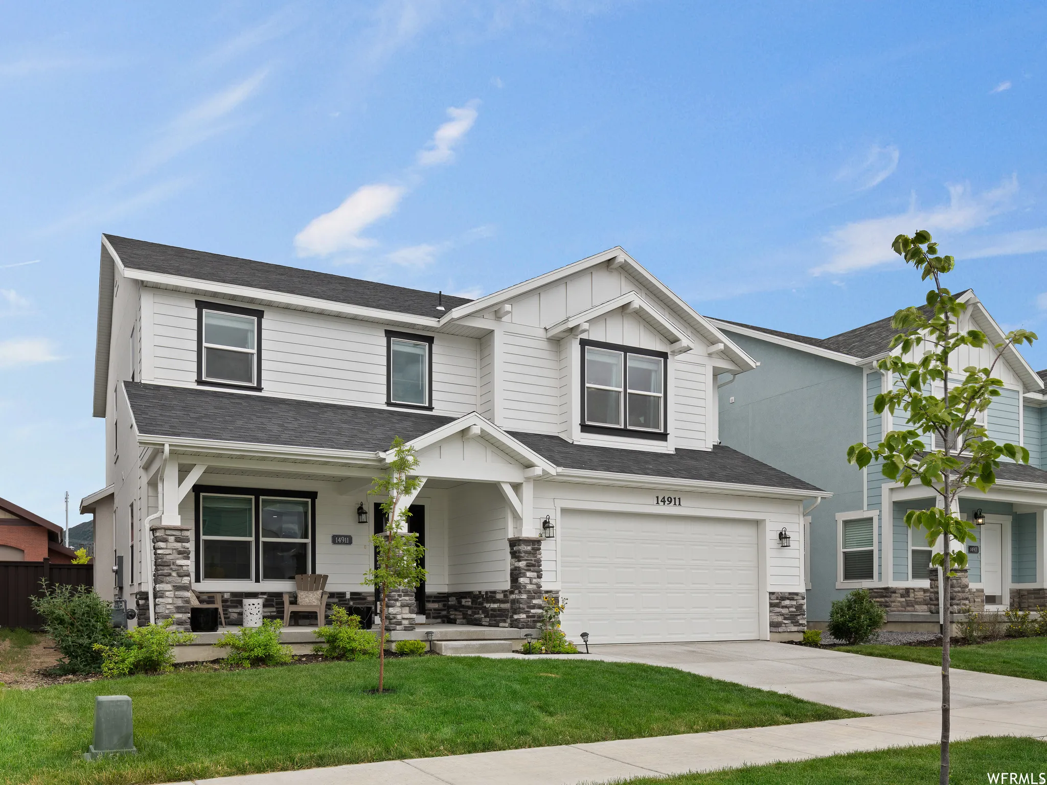 Craftsman-style house featuring a porch, stone siding, an attached garage, and concrete driveway