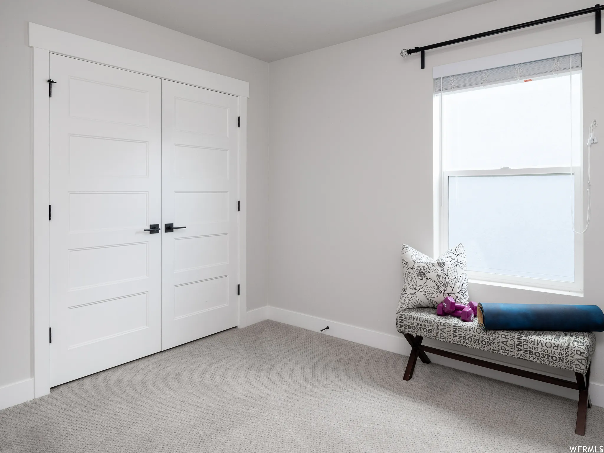 Living area featuring light carpet and baseboards