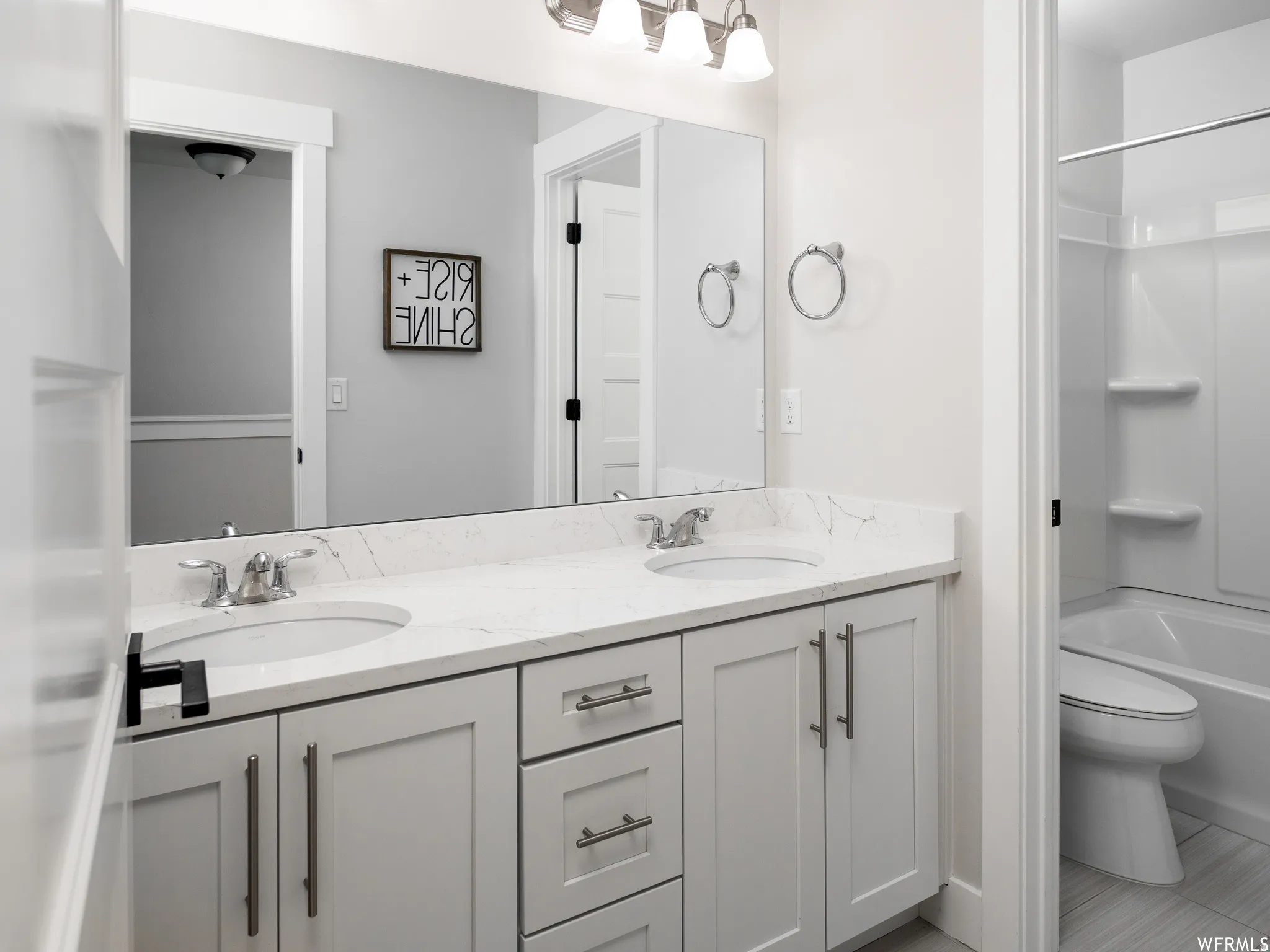 Full bathroom featuring double vanity and bathtub / shower combination
