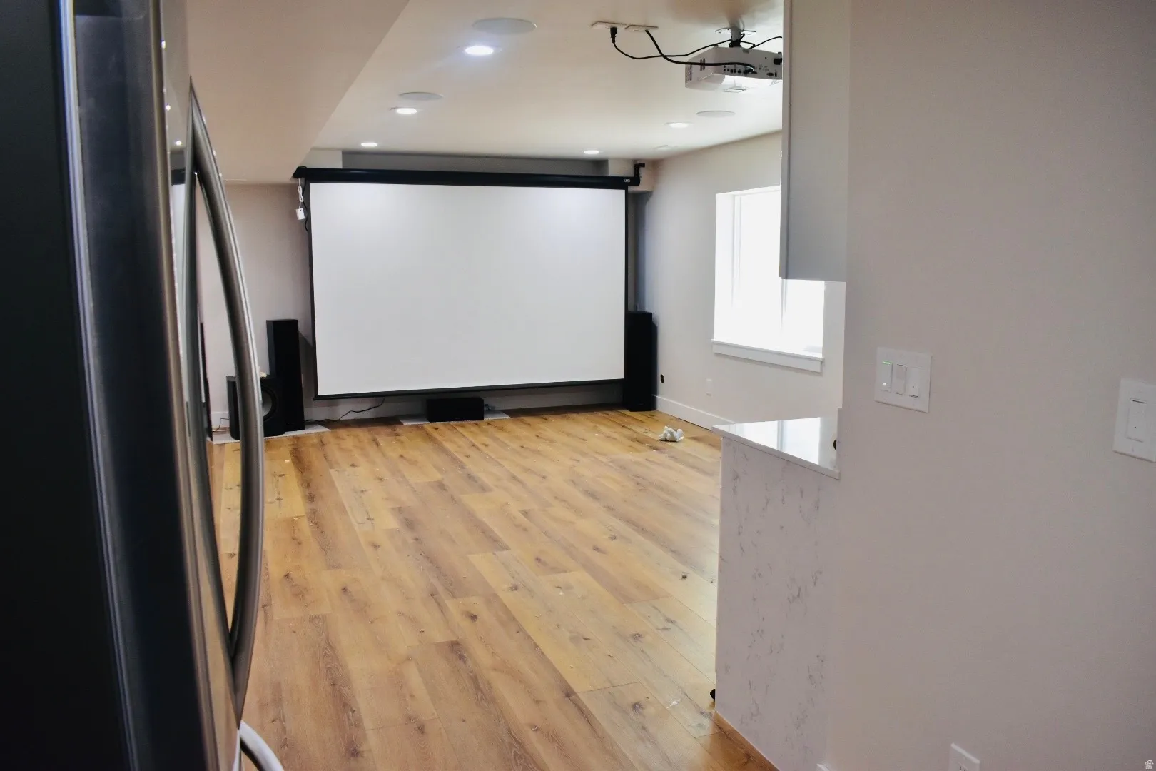 Cinema room featuring light wood finished floors and recessed lighting