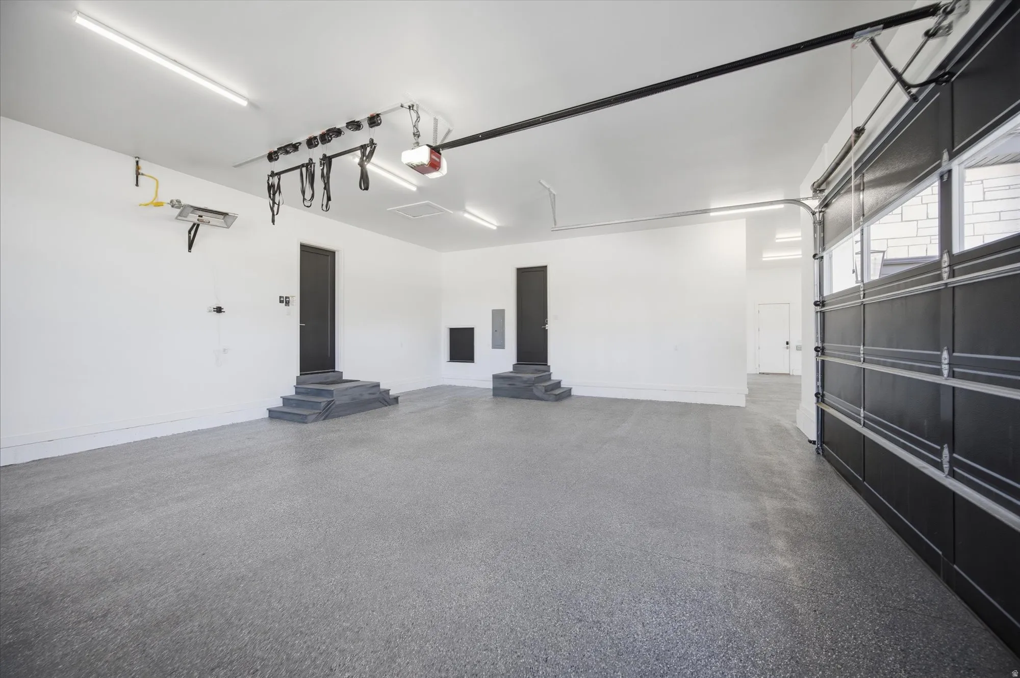 Garage with baseboards and a garage door opener