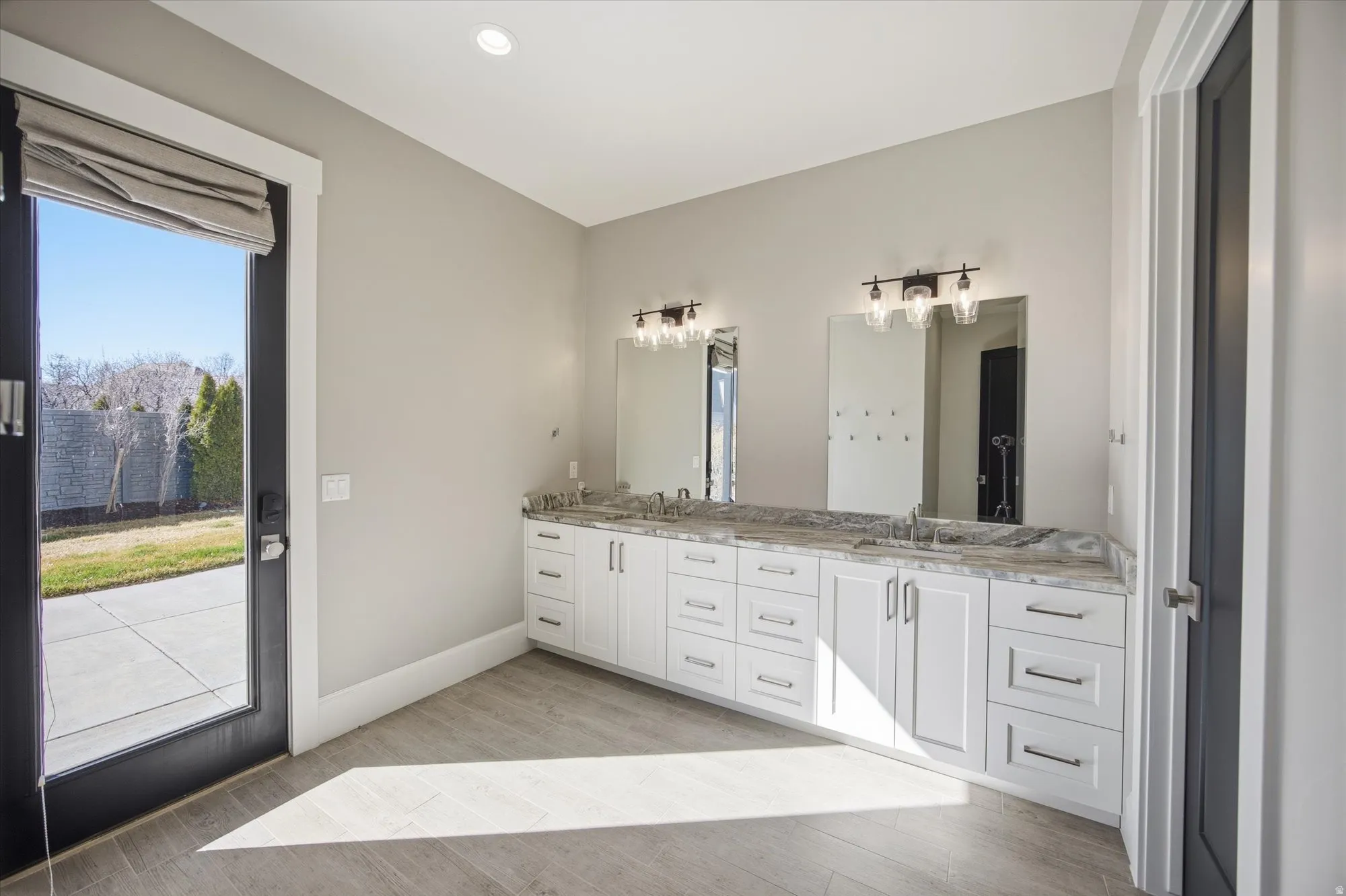 Bathroom featuring double vanity and light wood-style floors