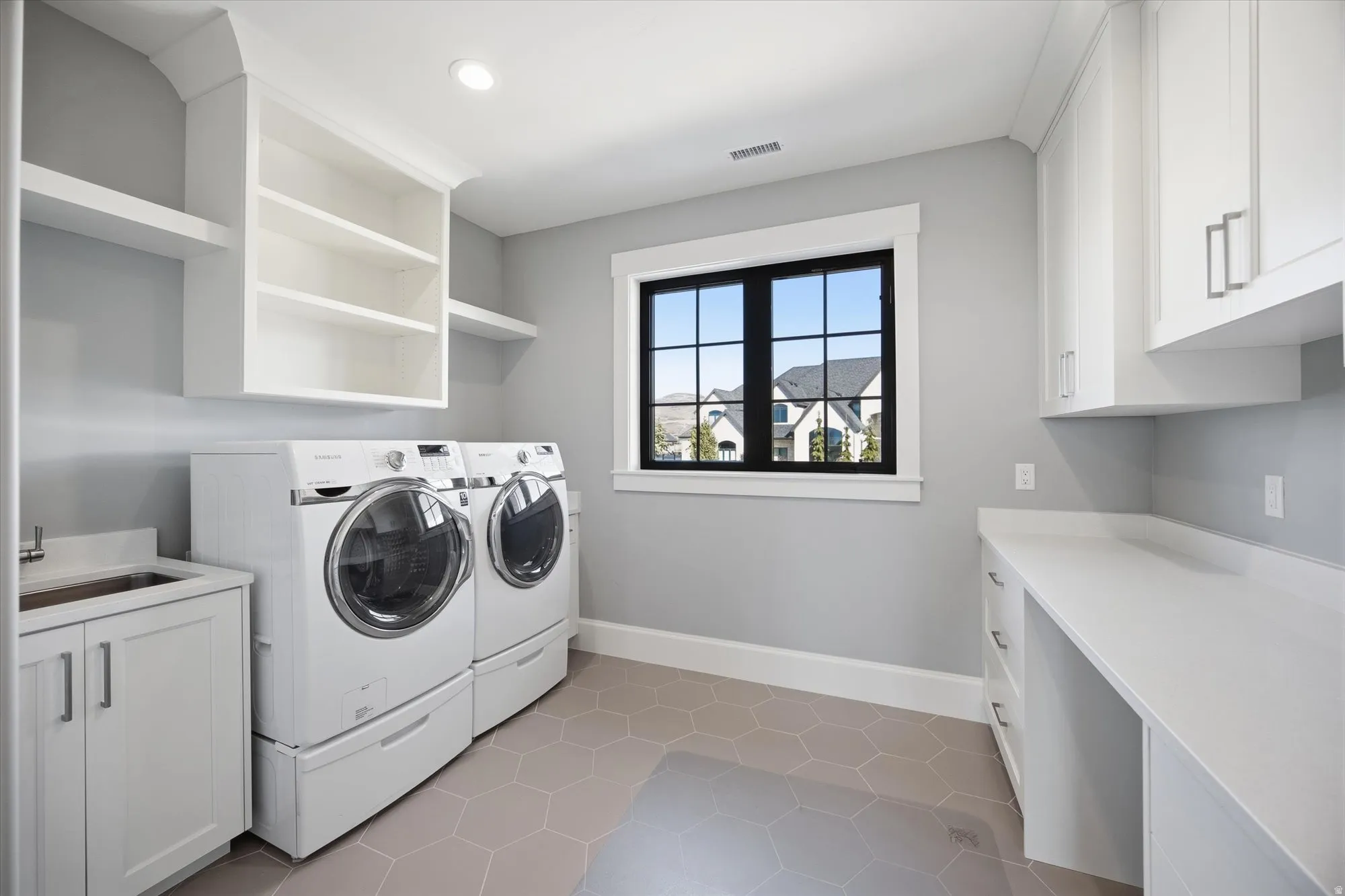 Laundry room with light tile patterned floors, cabinet space, and washing machine and dryer