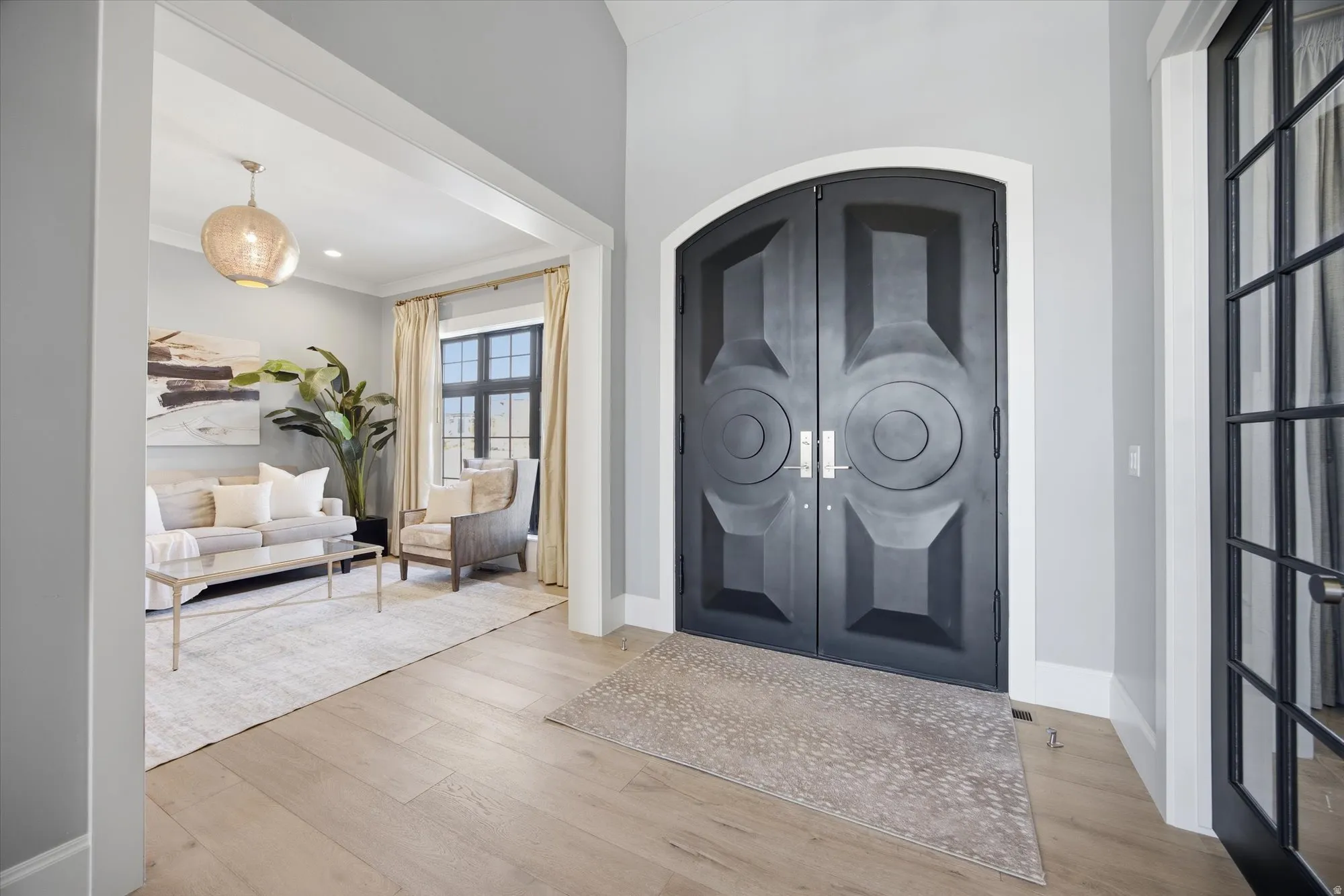 Foyer with french doors, arched walkways, and light wood-type flooring