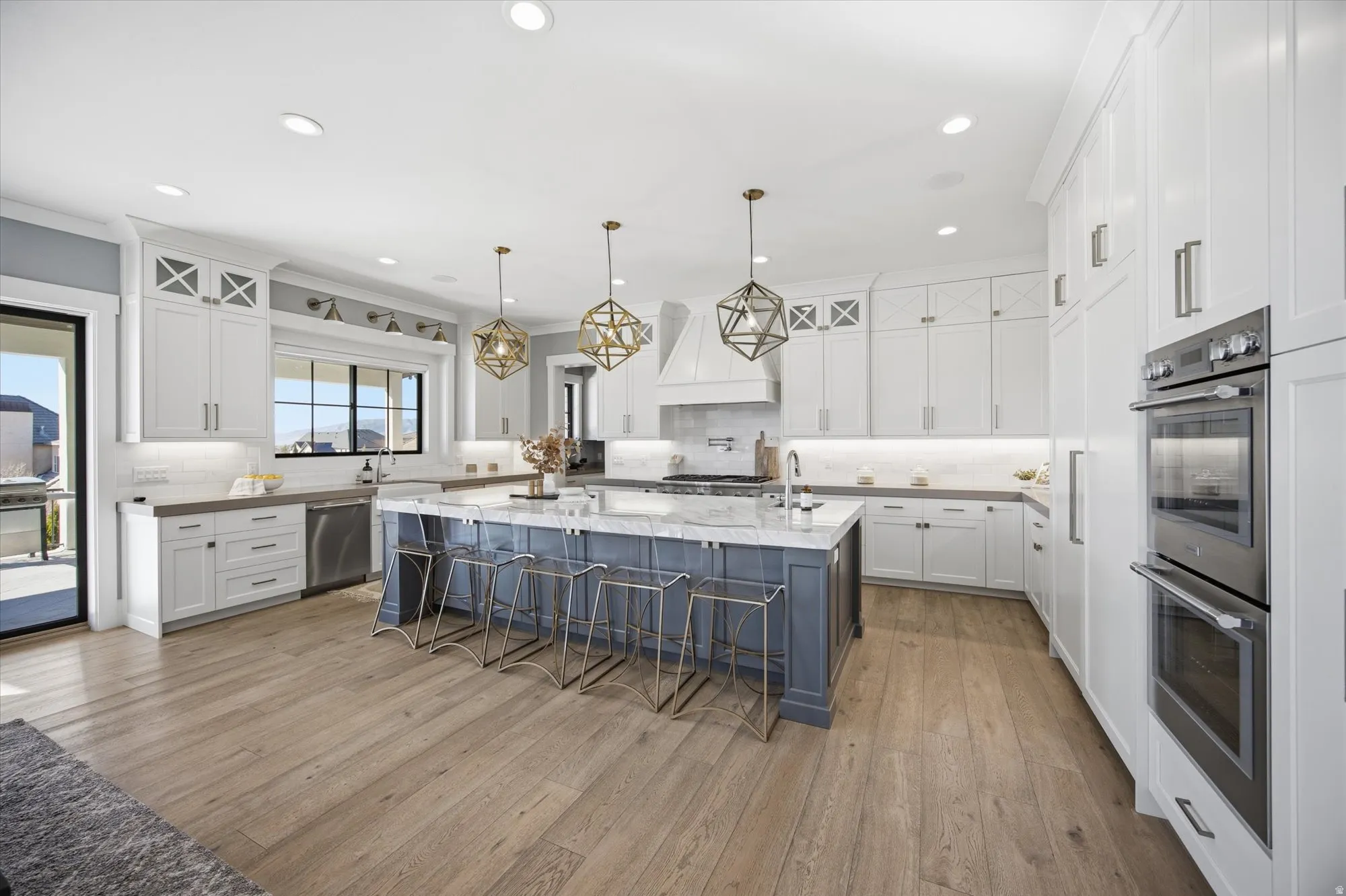 Dual tone kitchen featuring a breakfast bar, stainless steel appliances, decorative backsplash, a large island with sink, and two tone cabinets
