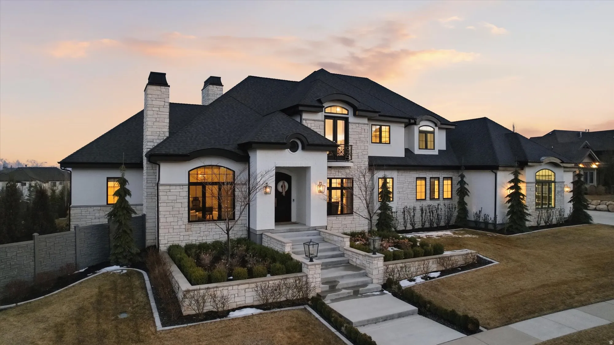 French provincial home with stucco siding, a chimney, stone siding, and a yard