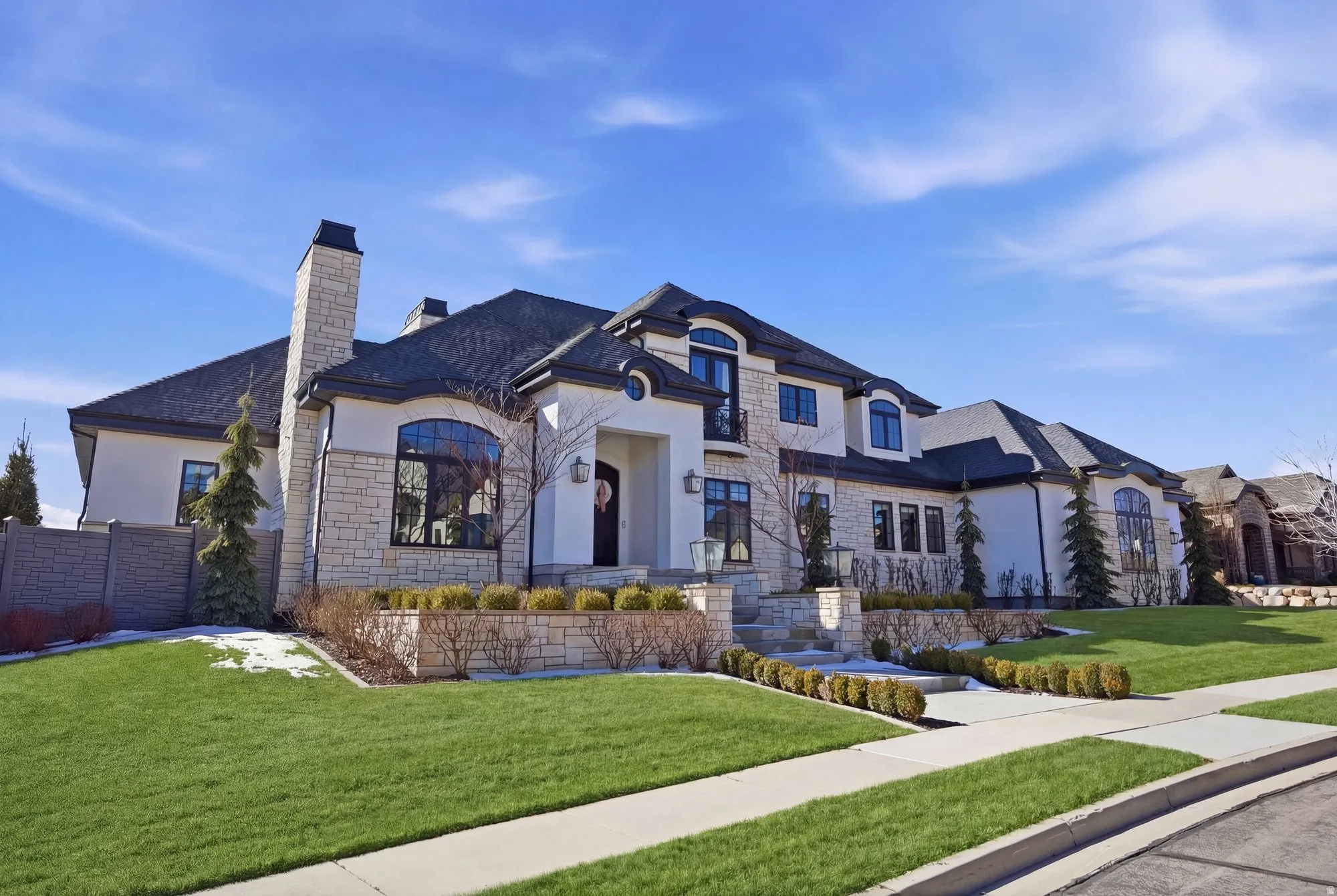 French country home featuring stucco siding, stone siding, and a chimney