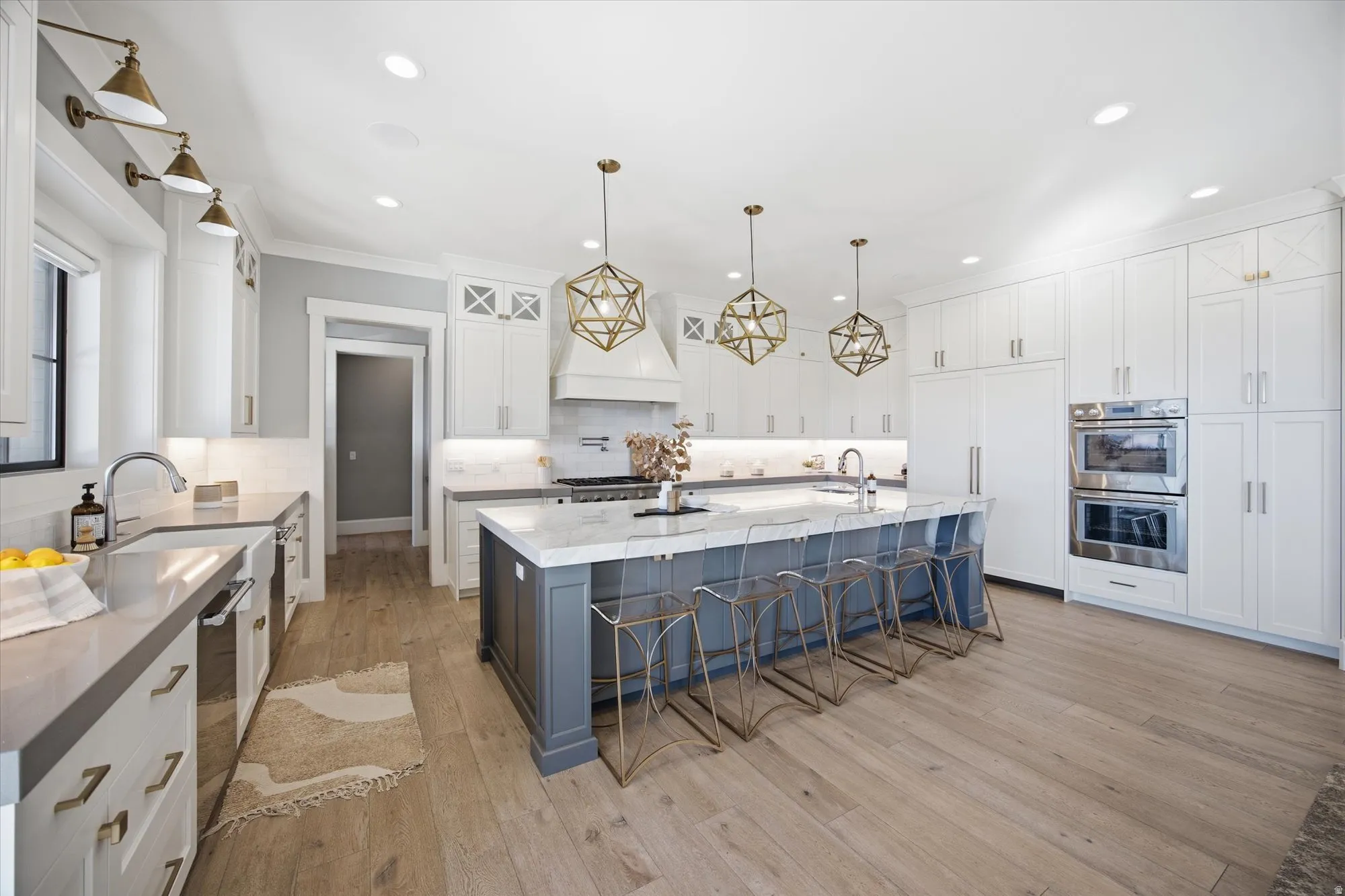 Kitchen with a kitchen bar, a spacious island, stainless steel appliances, two tone cabinetry, and dark stone countertops