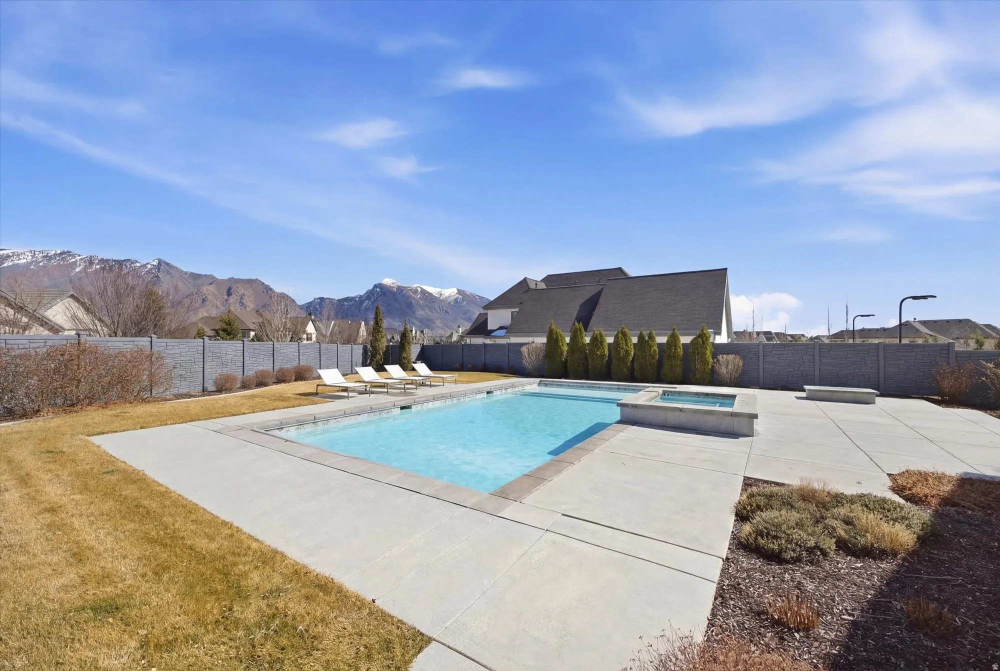 Relaxing pool / spa with a patio, a fenced backyard, and a mountain view