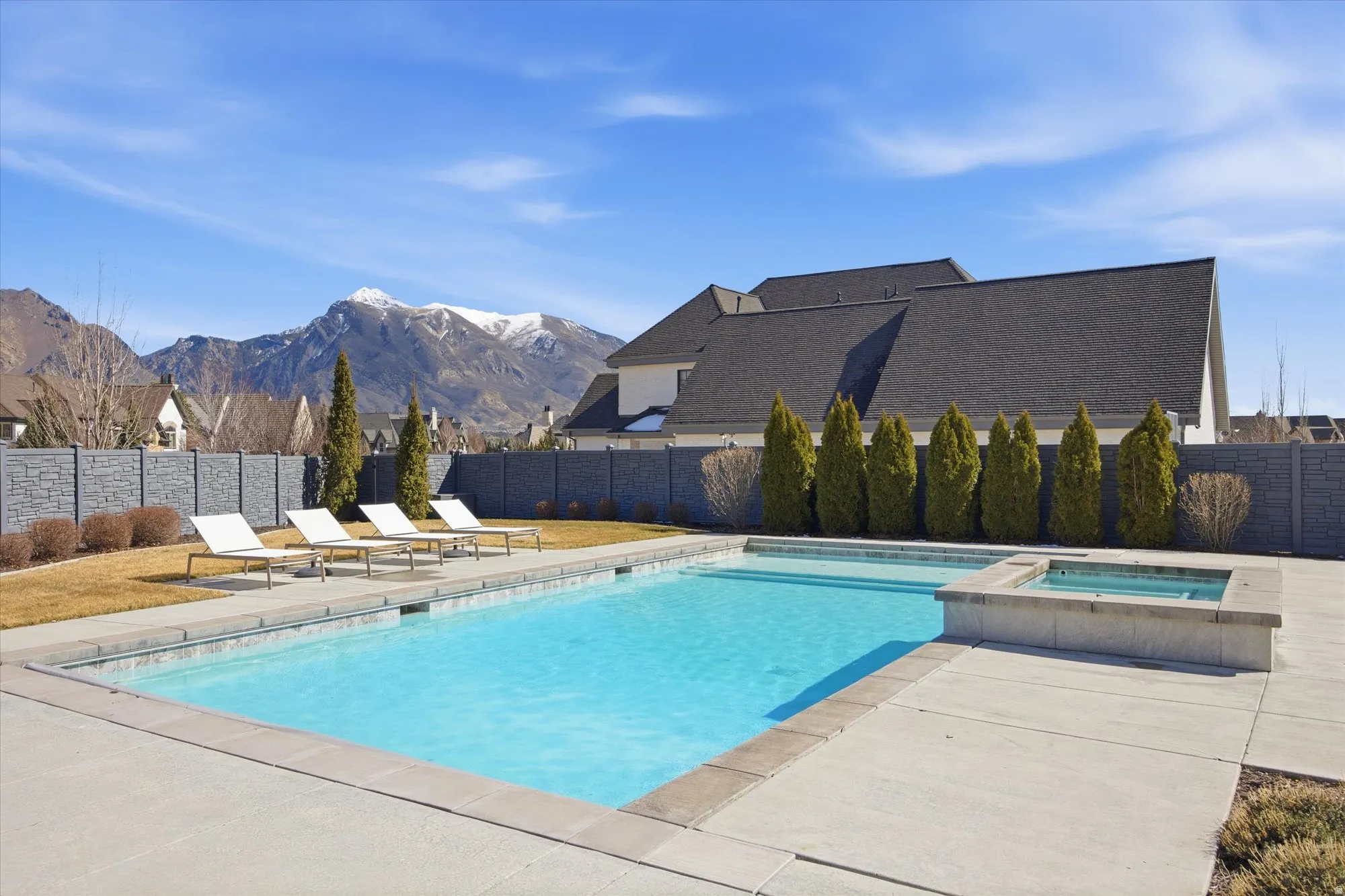 Relaxing pool / spa with a patio area, a mountain view, and a fenced backyard
