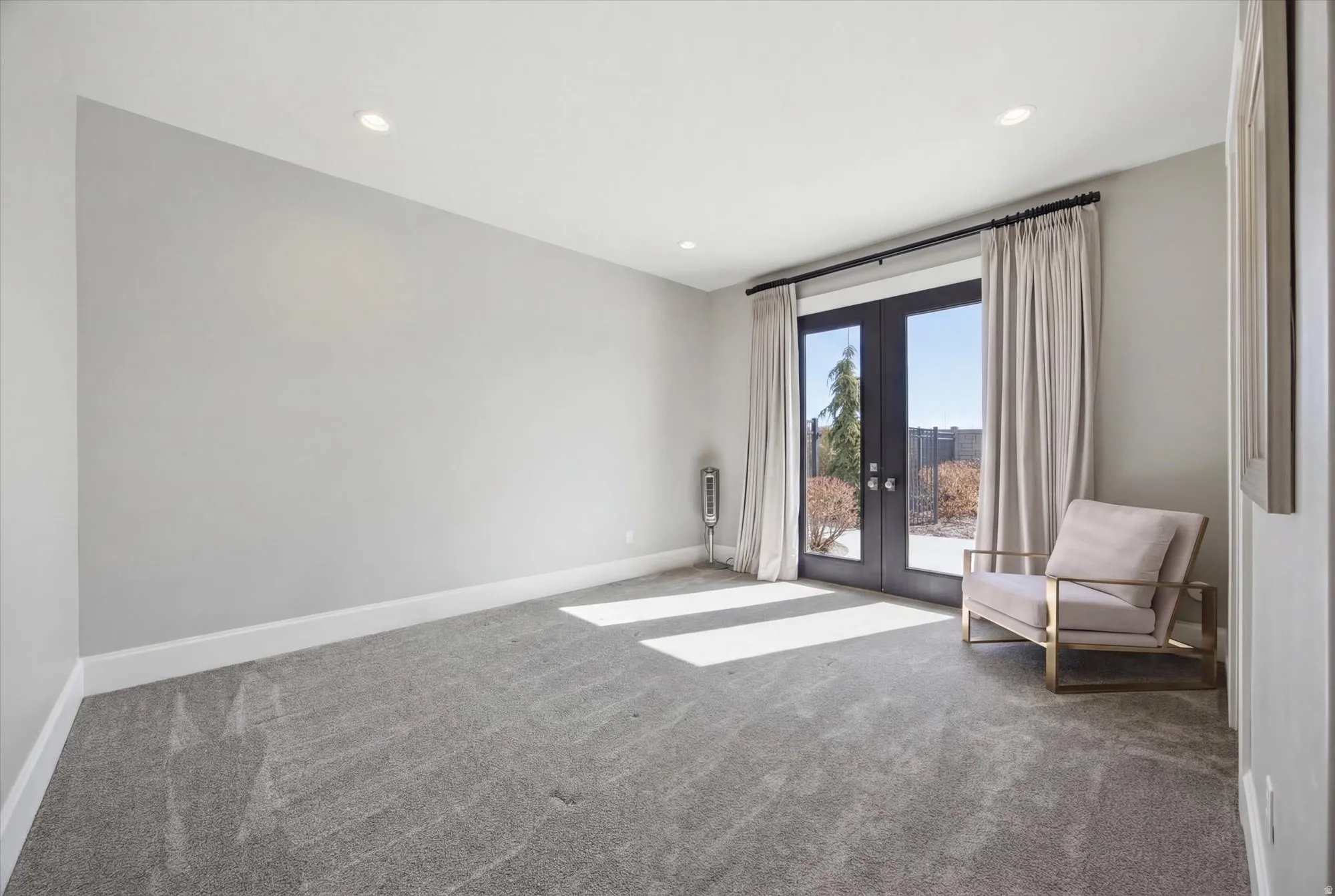 Empty room featuring french doors, light carpet, and recessed lighting