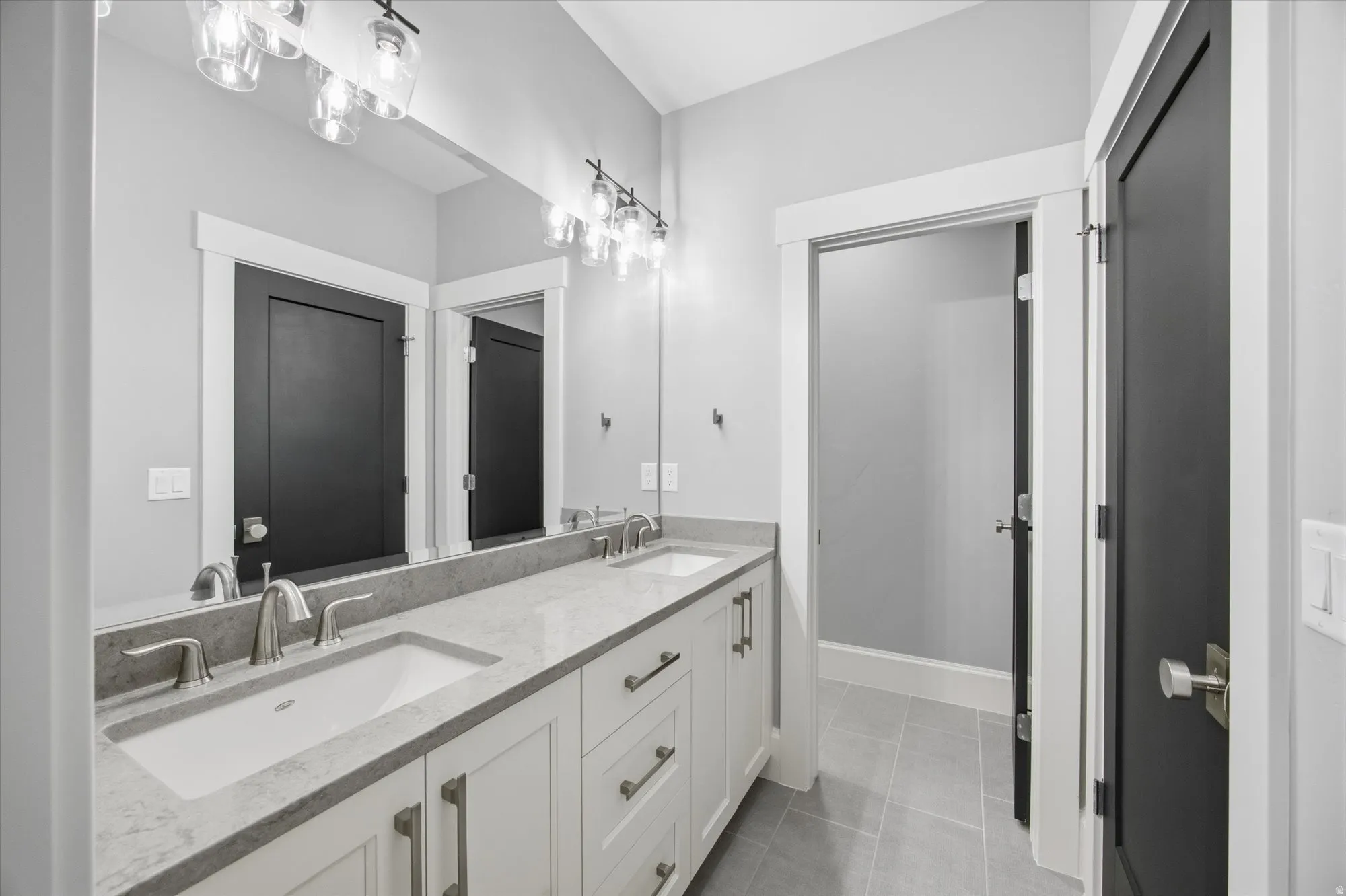 Bathroom featuring double vanity and light tile patterned floors