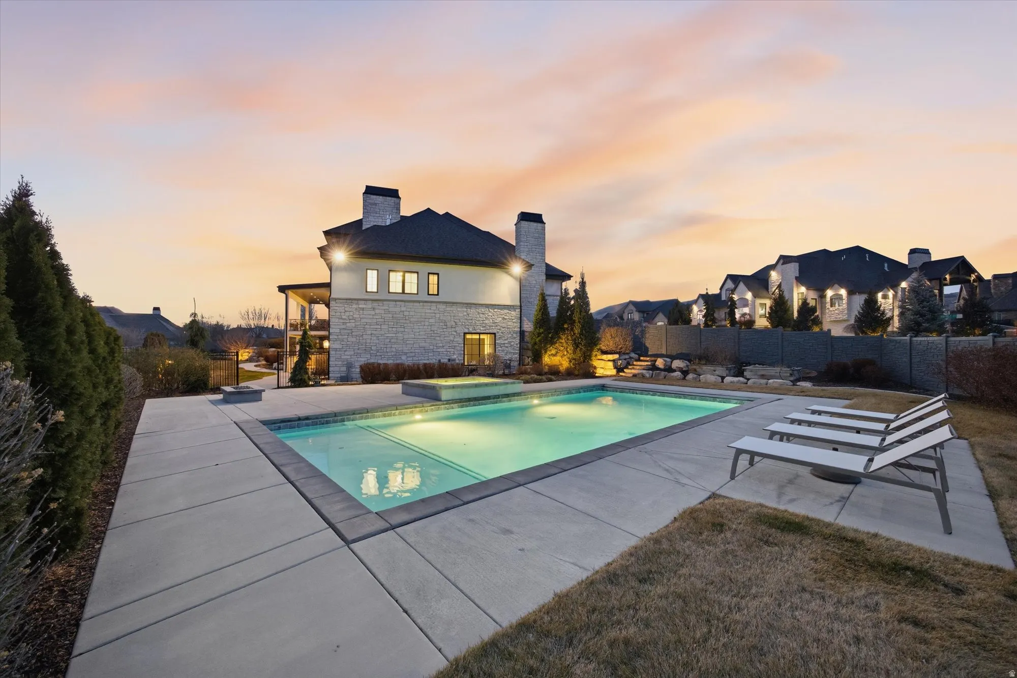 Pool at dusk featuring a patio