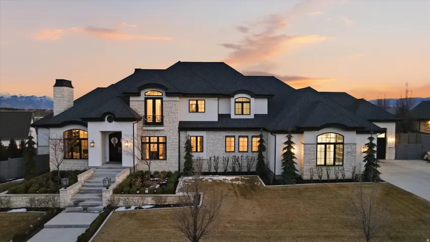 French country inspired facade with a chimney and stucco siding