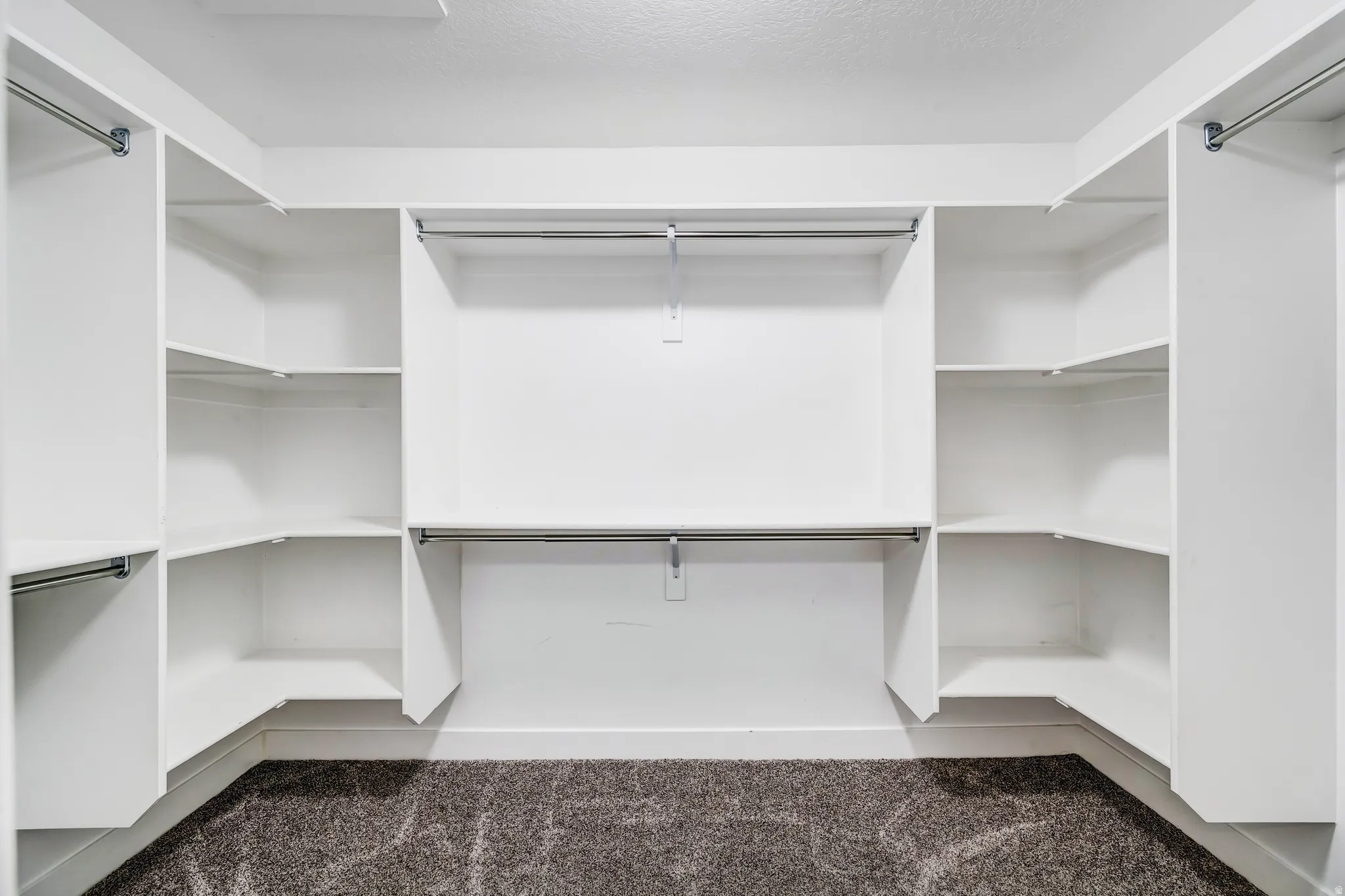 Walk in closet featuring dark carpet