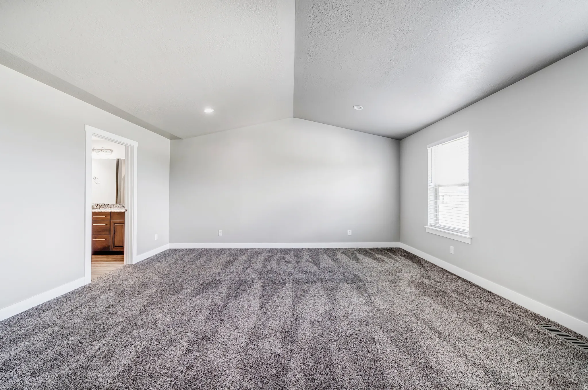 Primary bedroom with vaulted ceiling