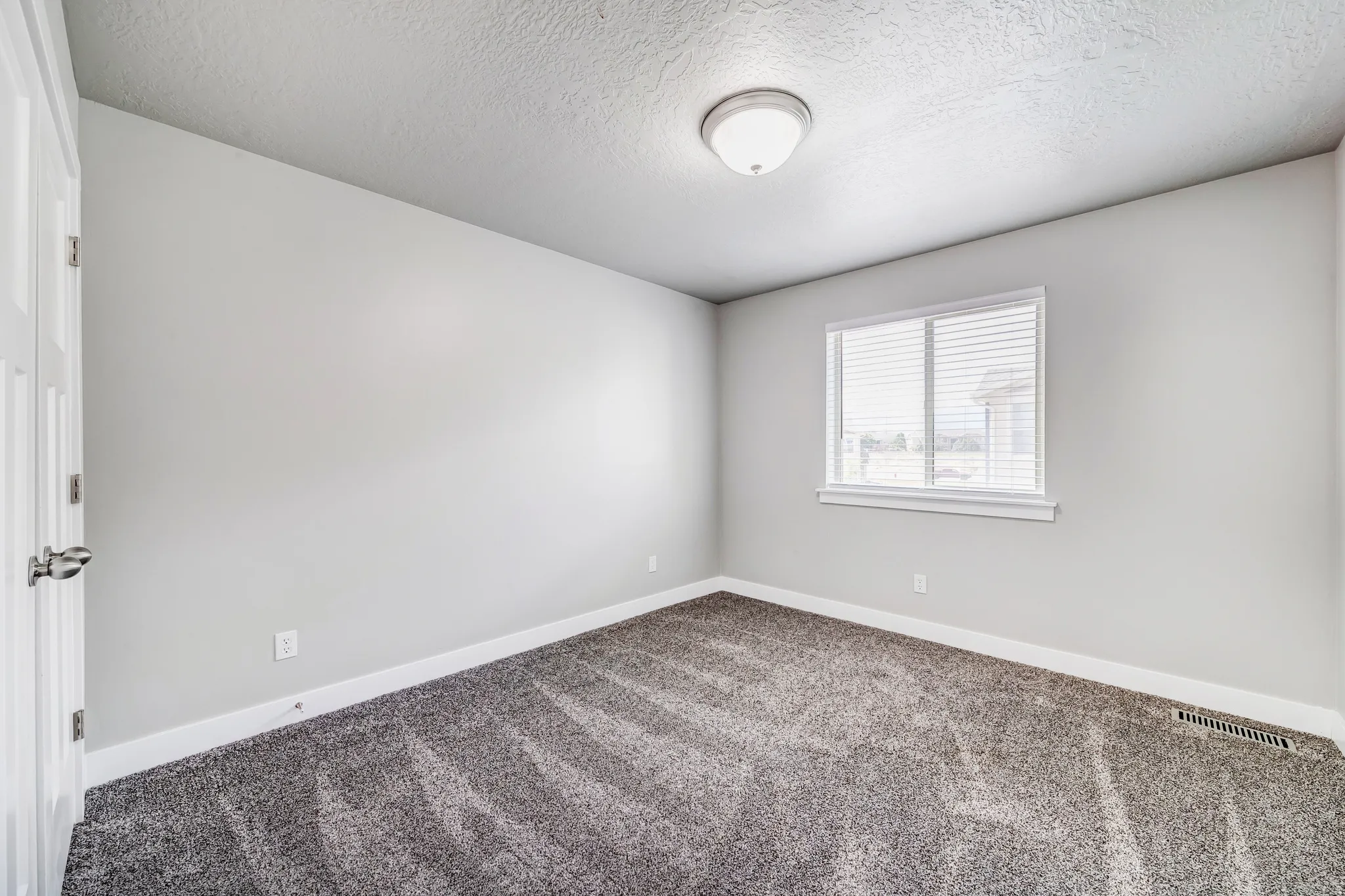Carpeted empty room featuring baseboards and a textured ceiling