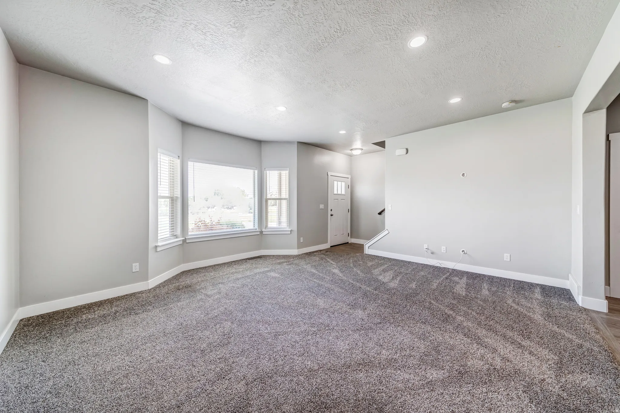 Carpeted empty room with recessed lighting and a textured ceiling