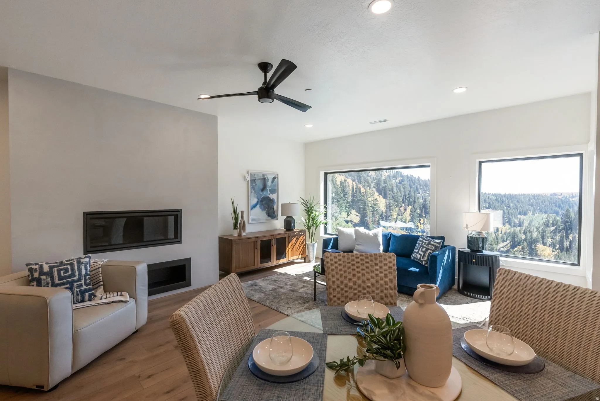 Dining area with wood finished floors, ceiling fan, a glass covered fireplace, and recessed lighting