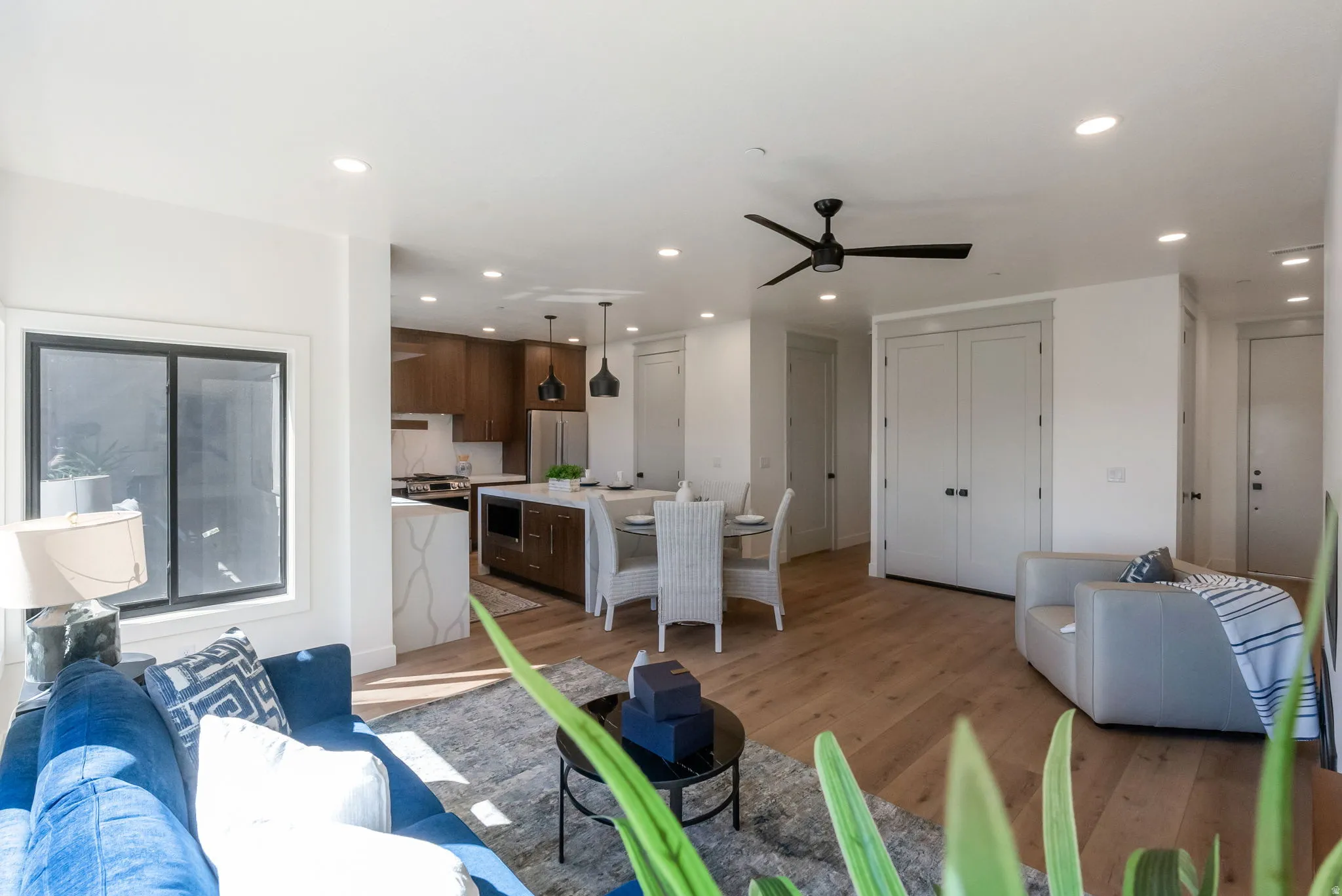 Living room with light wood-style flooring, a ceiling fan, and recessed lighting