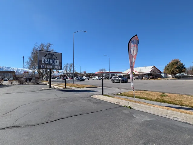 View of asphalt street featuring sidewalks, street lighting, and curbs