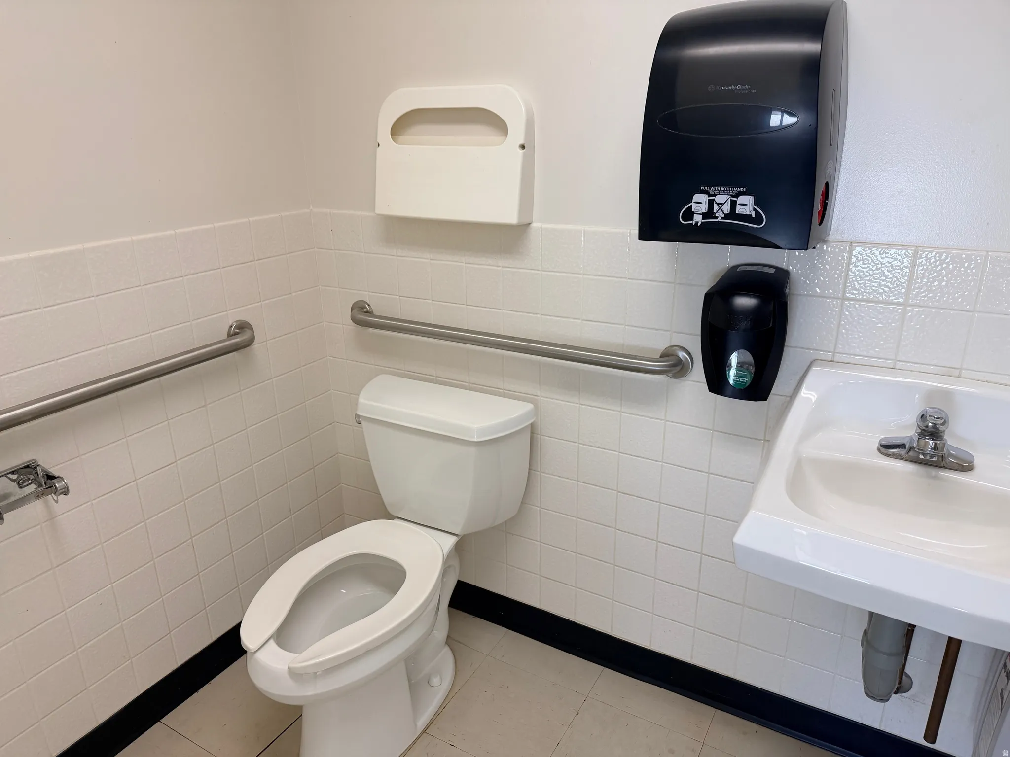Half bathroom featuring tile walls and wainscoting