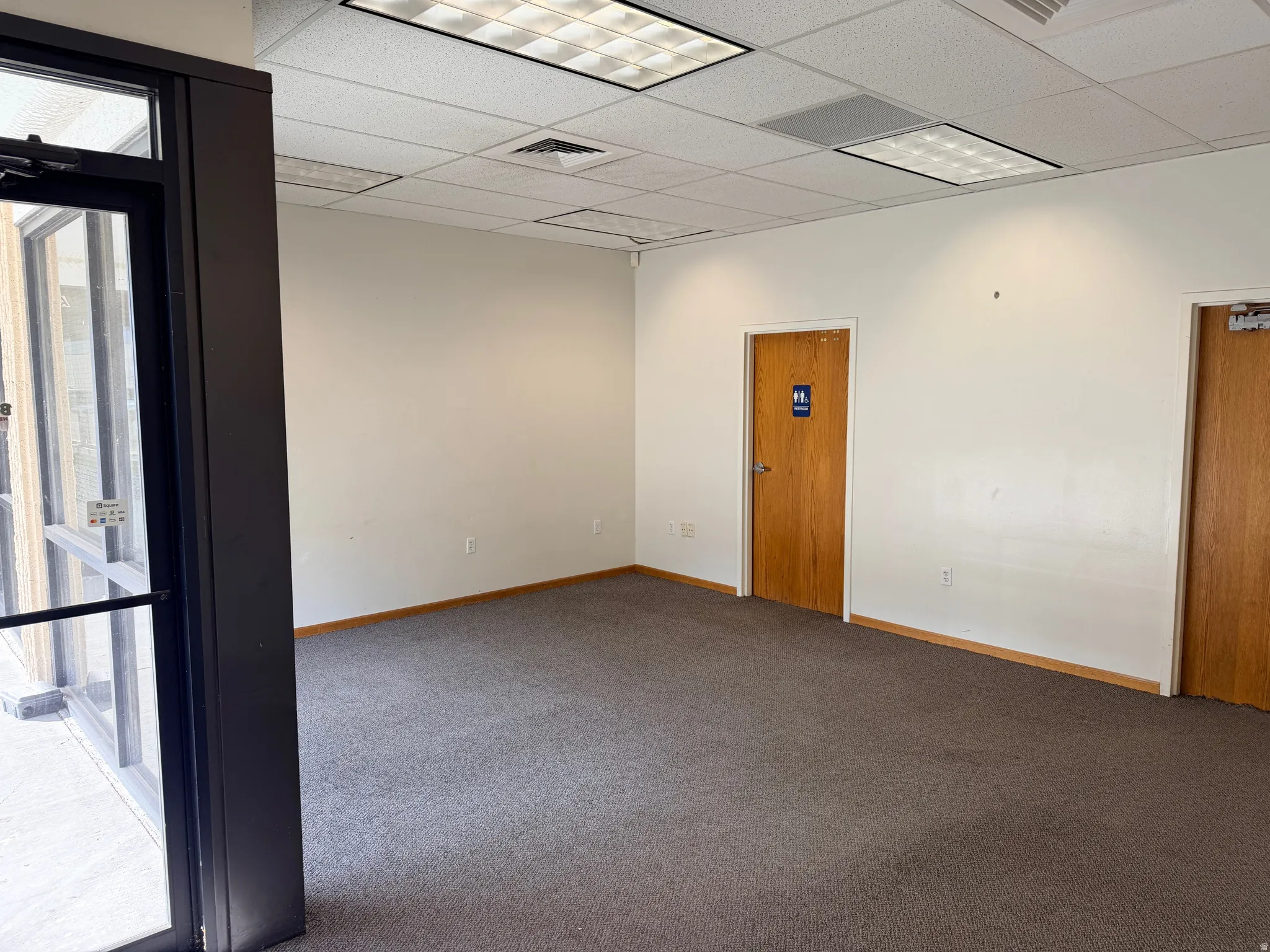 Spare room featuring carpet flooring and a paneled ceiling