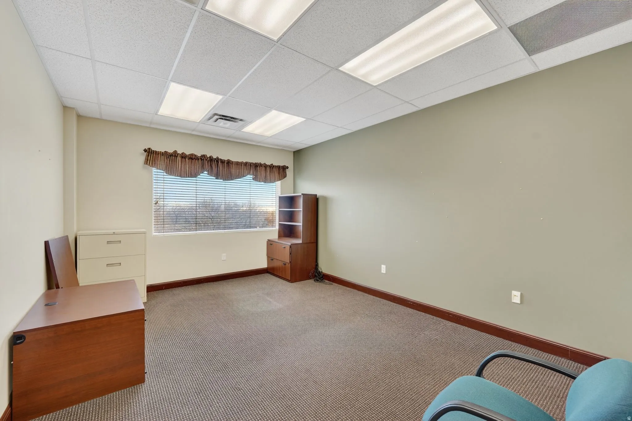 Interior space with light carpet and a paneled ceiling
