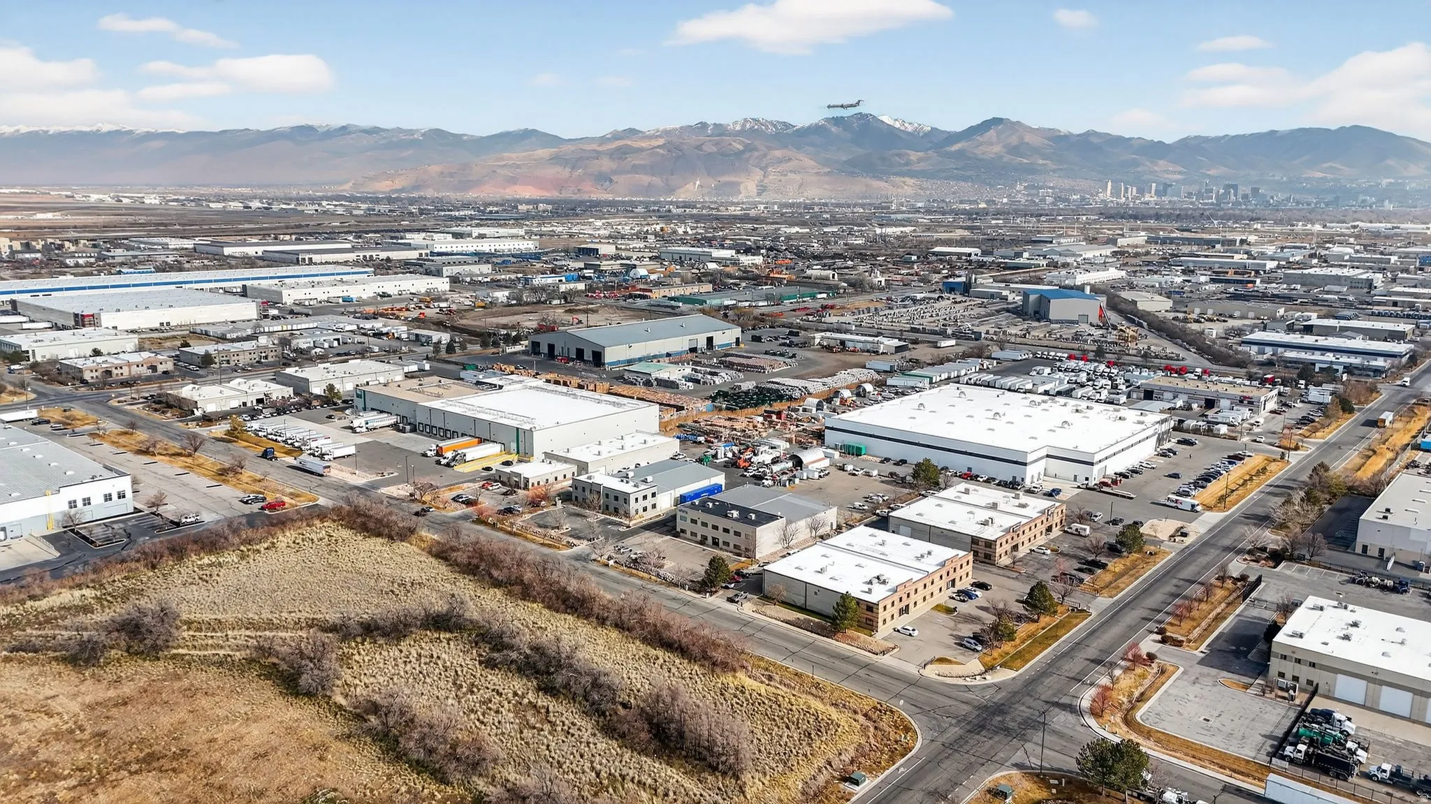 Aerial view of property's location featuring an industrial area and a mountain backdrop