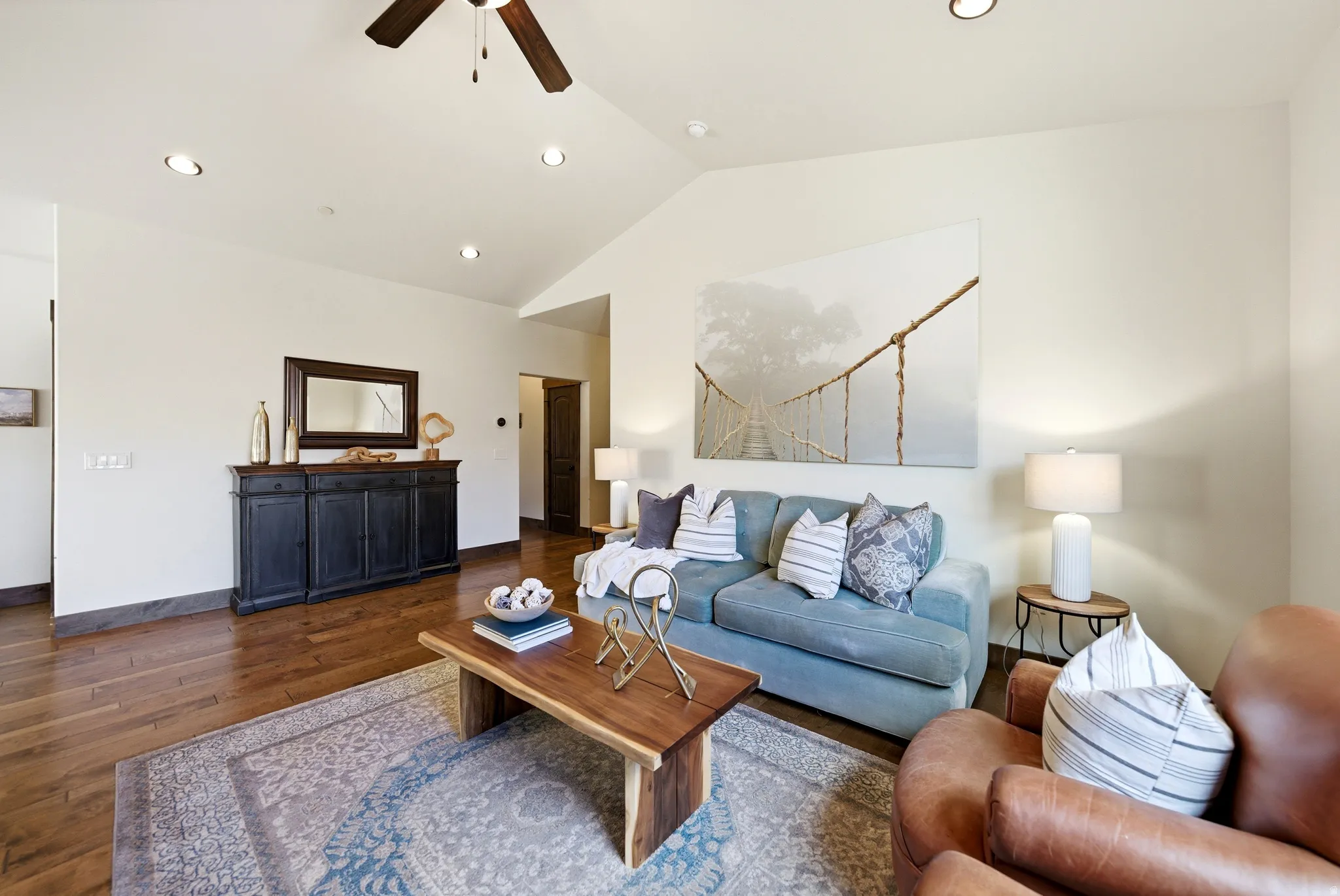 Fully furnished living area featuring wood-type flooring, a ceiling fan, a lofted ceiling, and recessed lighting