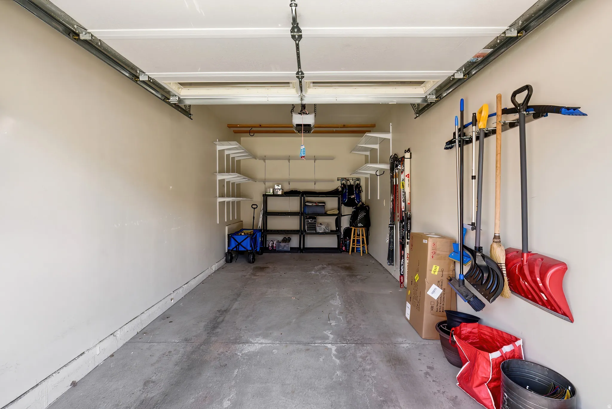 View of garage, built in shelving, secondary dedicated parking space directly behind