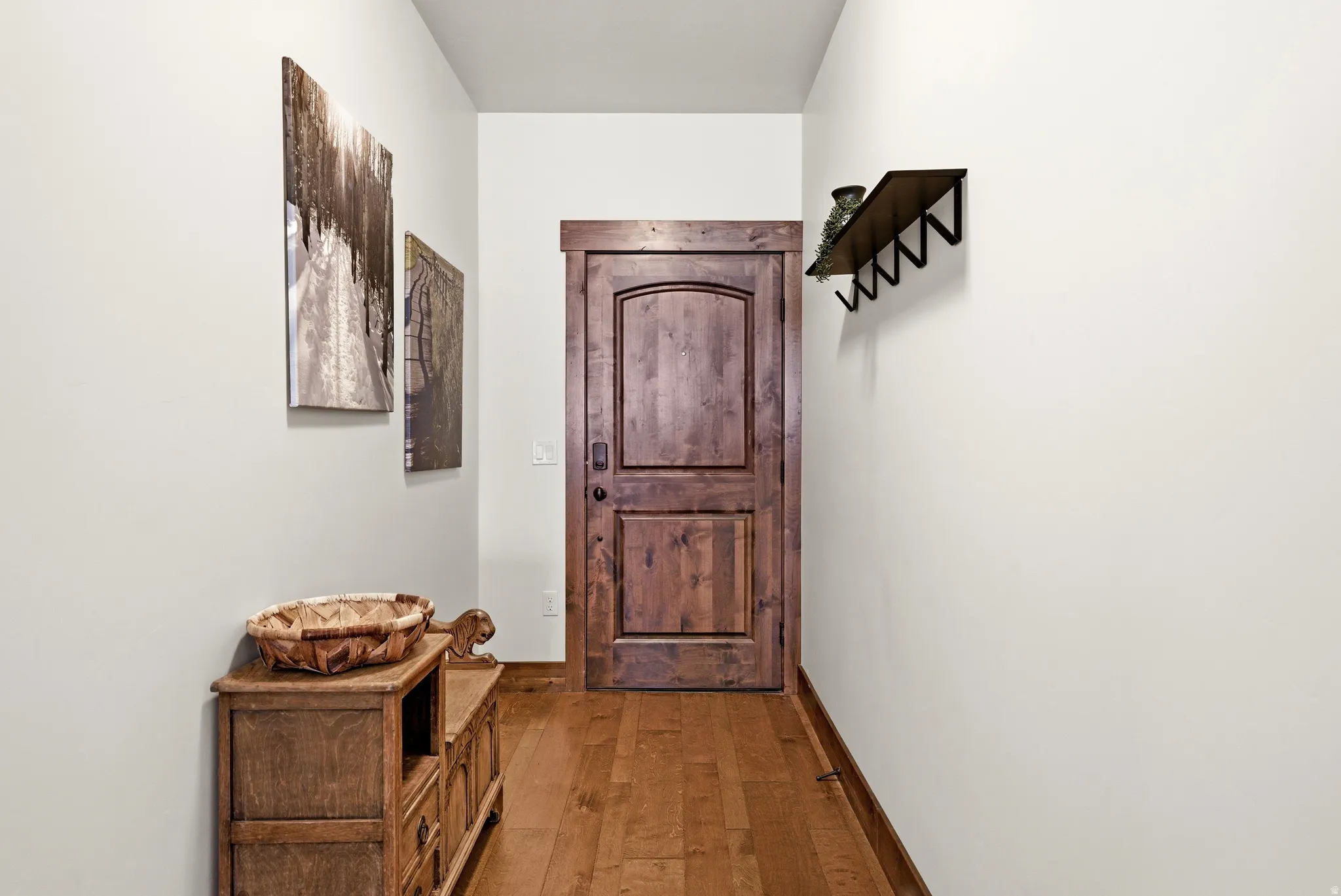 Doorway with wood-type flooring and baseboards