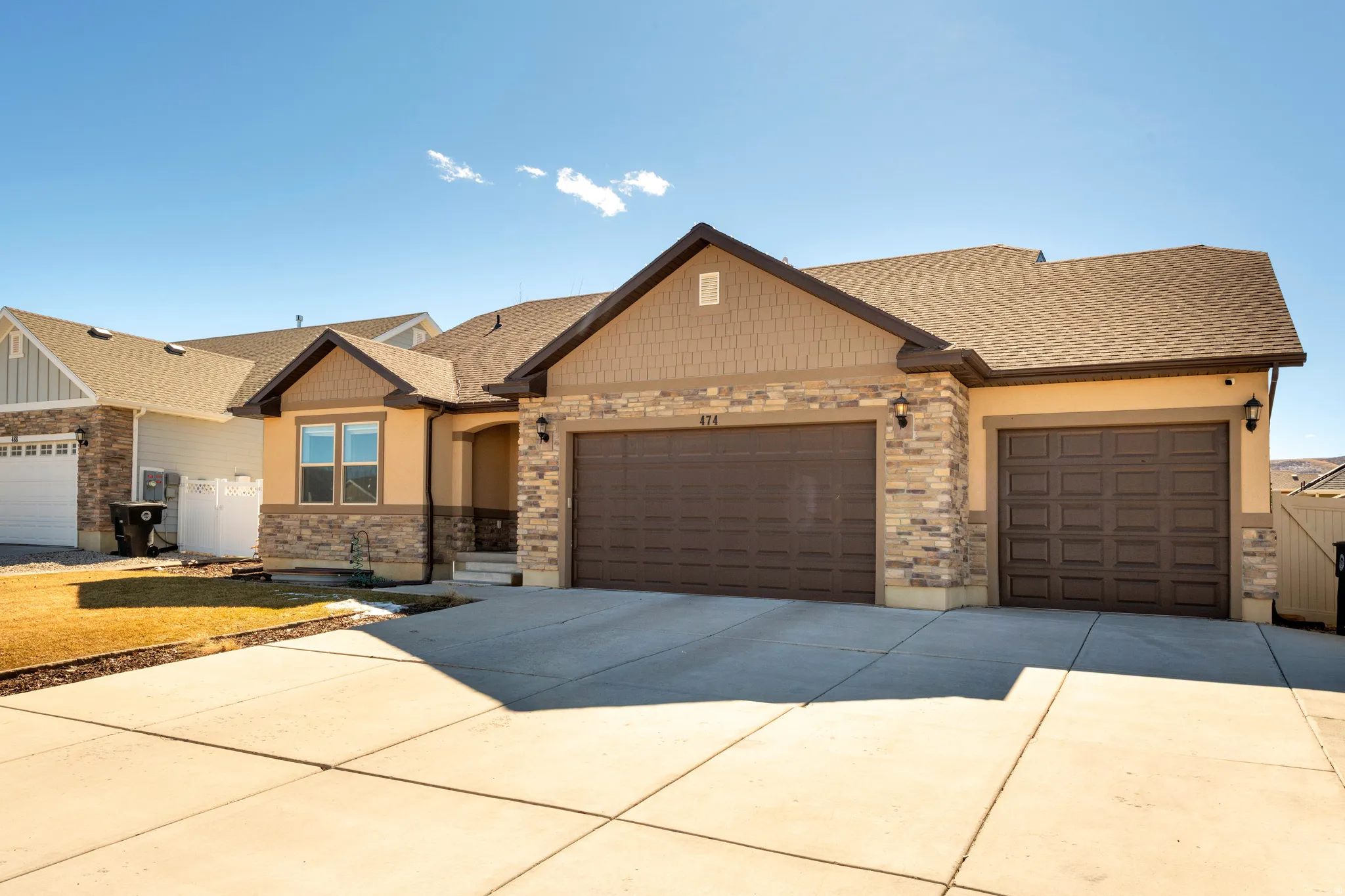 Craftsman inspired home featuring an attached garage, a shingled roof, concrete driveway, and stone siding
