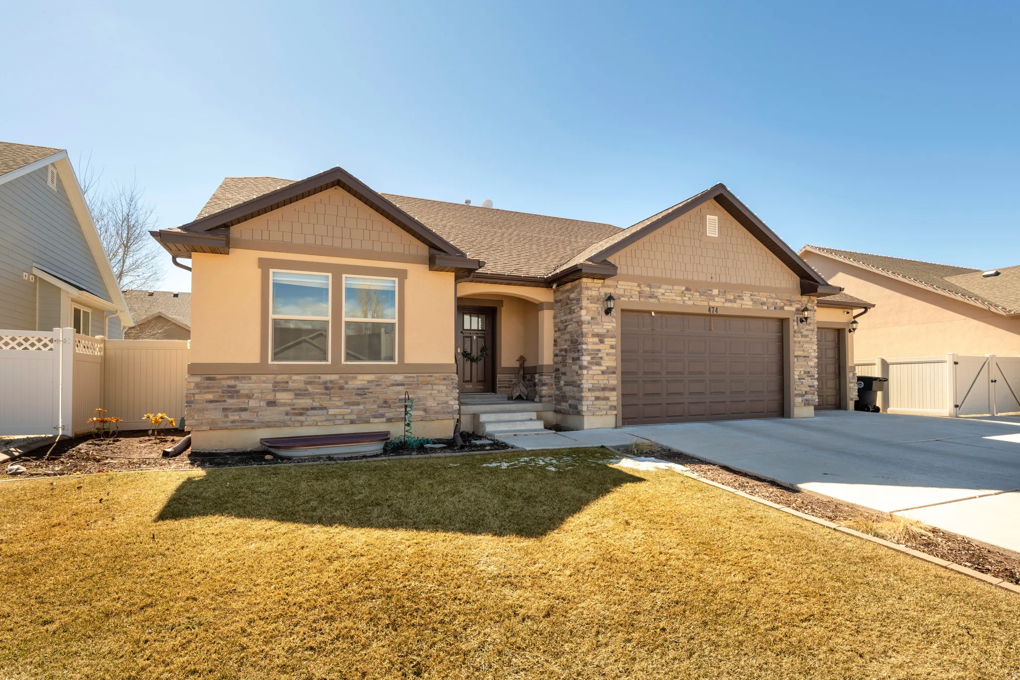 Craftsman house featuring a gate, an attached garage, concrete driveway, stone siding, and a shingled roof