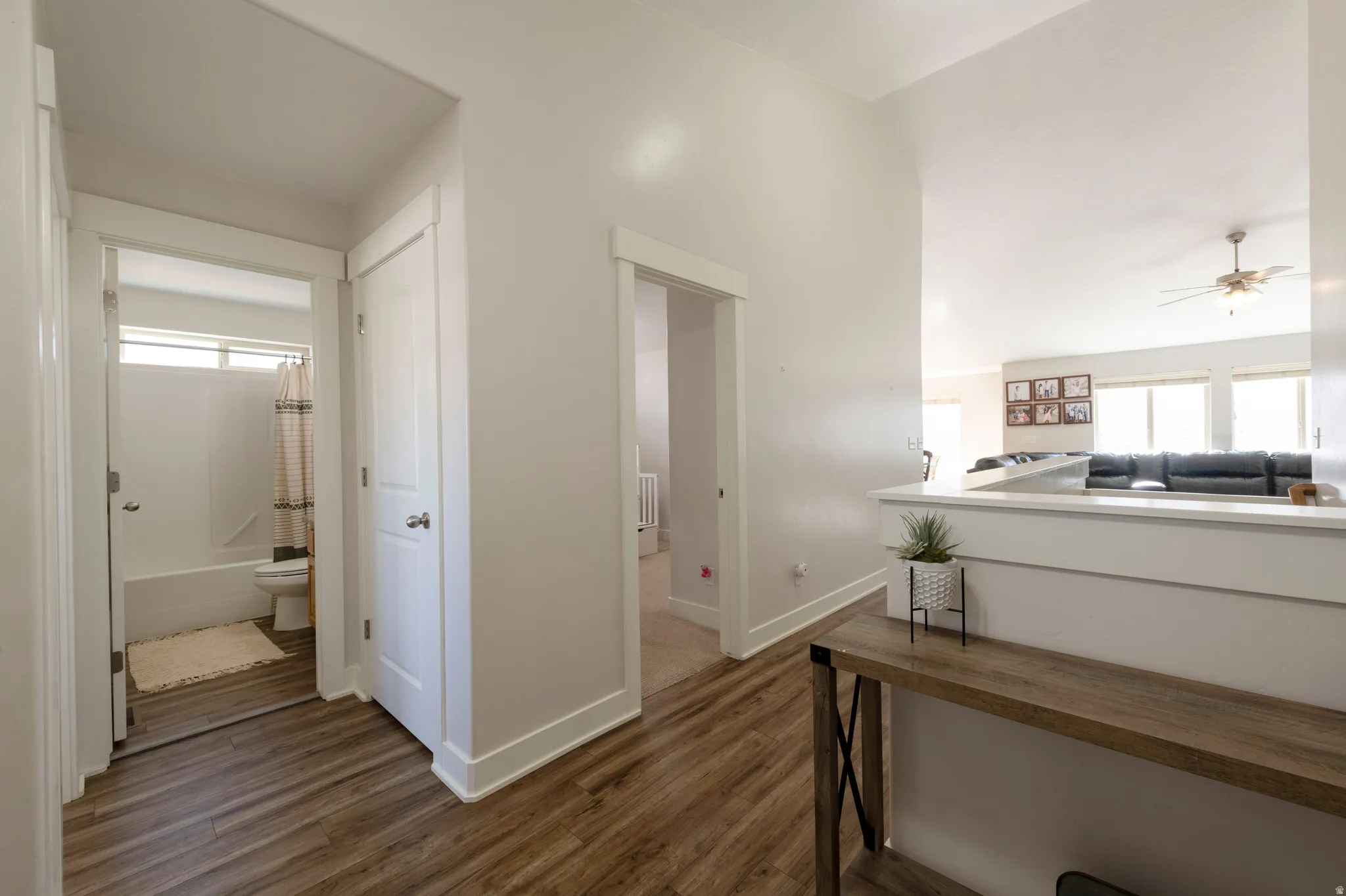 Hall featuring healthy amount of natural light and dark wood finished floors
