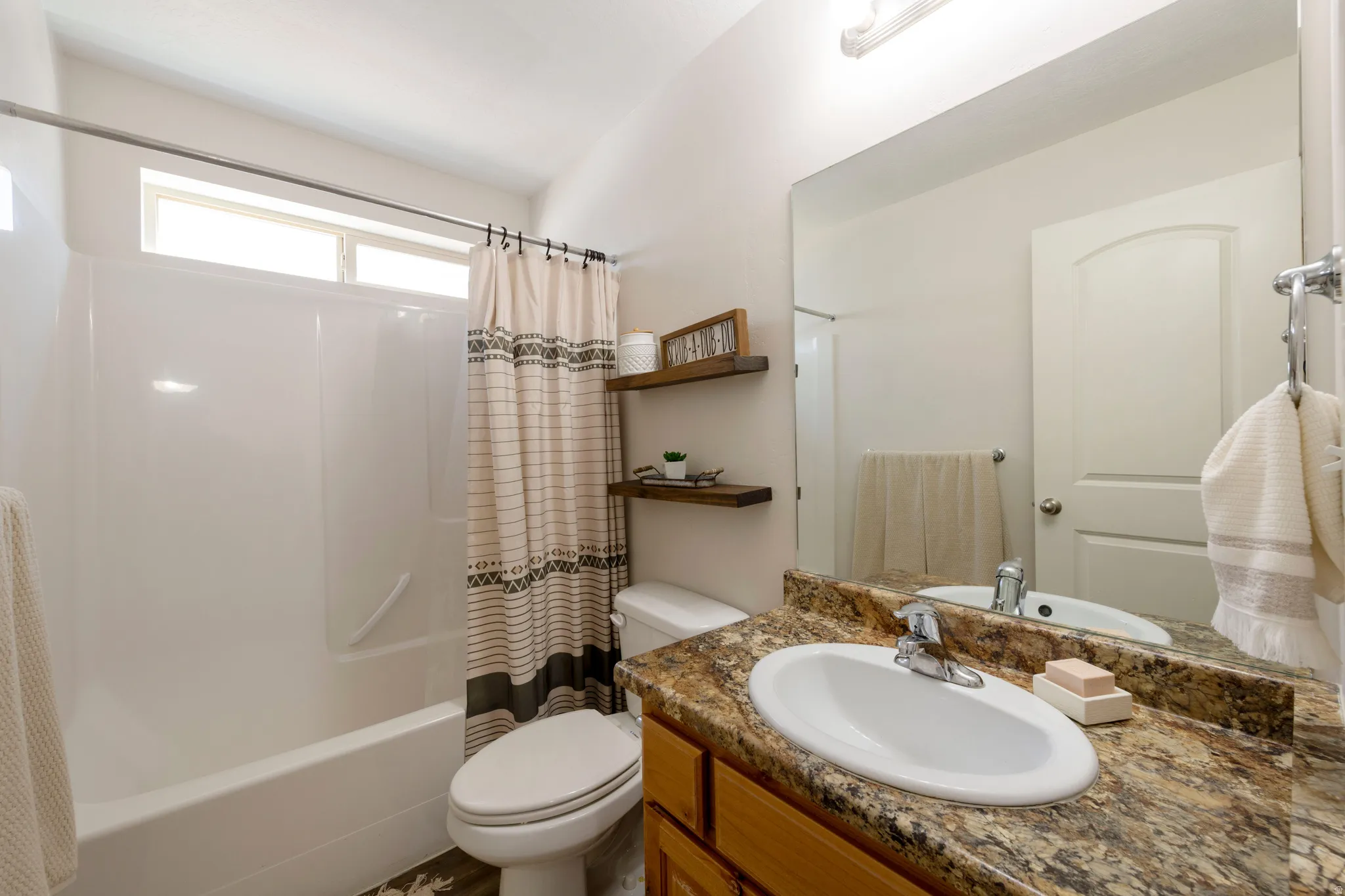 Bathroom featuring vanity and shower / bath combination with curtain