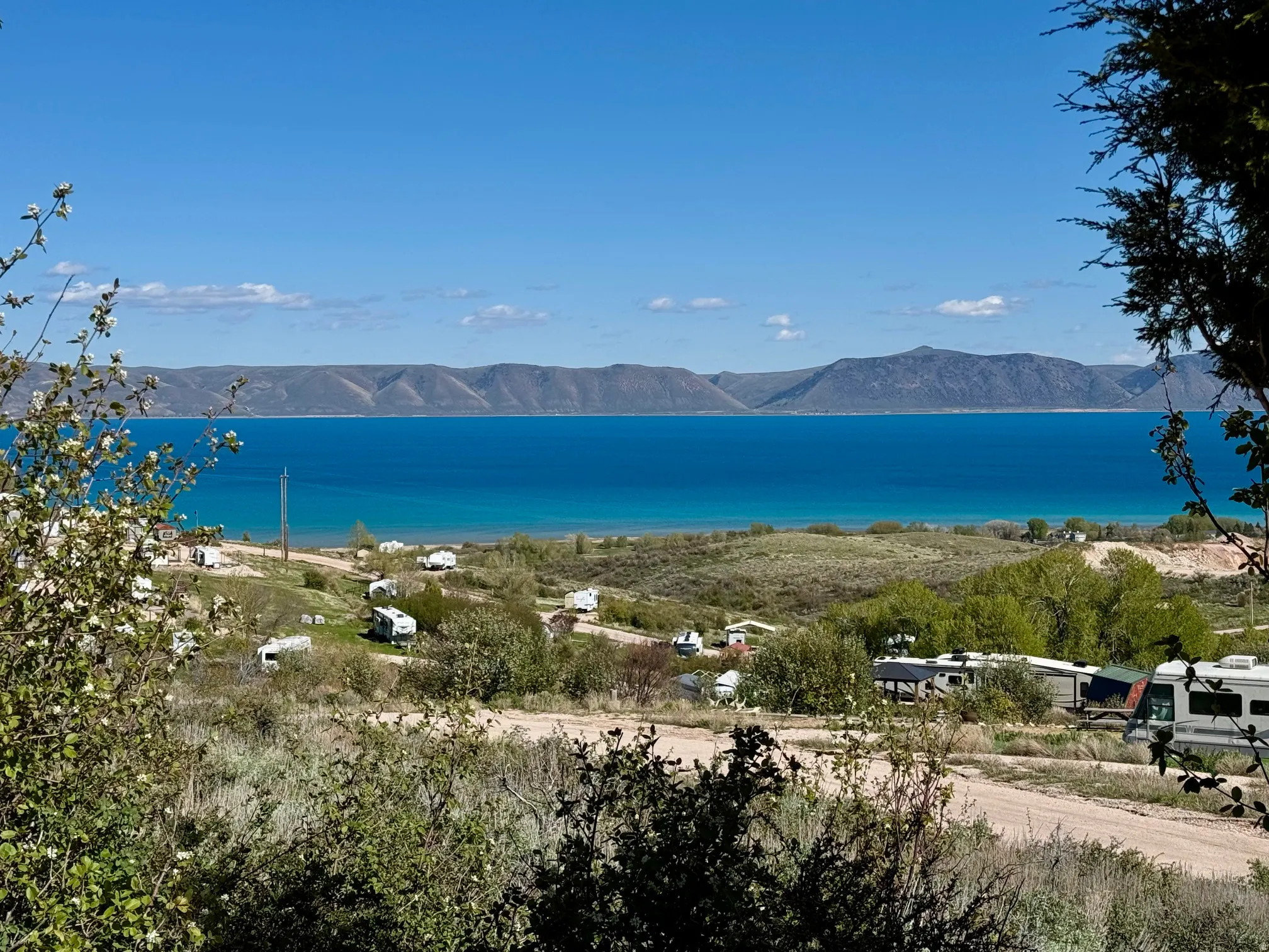 Expansive water frontage with a vibrant turquoise hue, complemented by distant mountain ranges