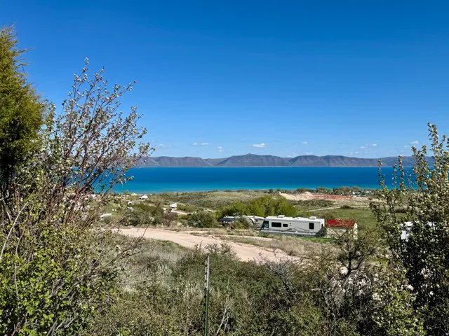 Expansive water frontage with a vibrant turquoise hue, complemented by distant mountain ranges