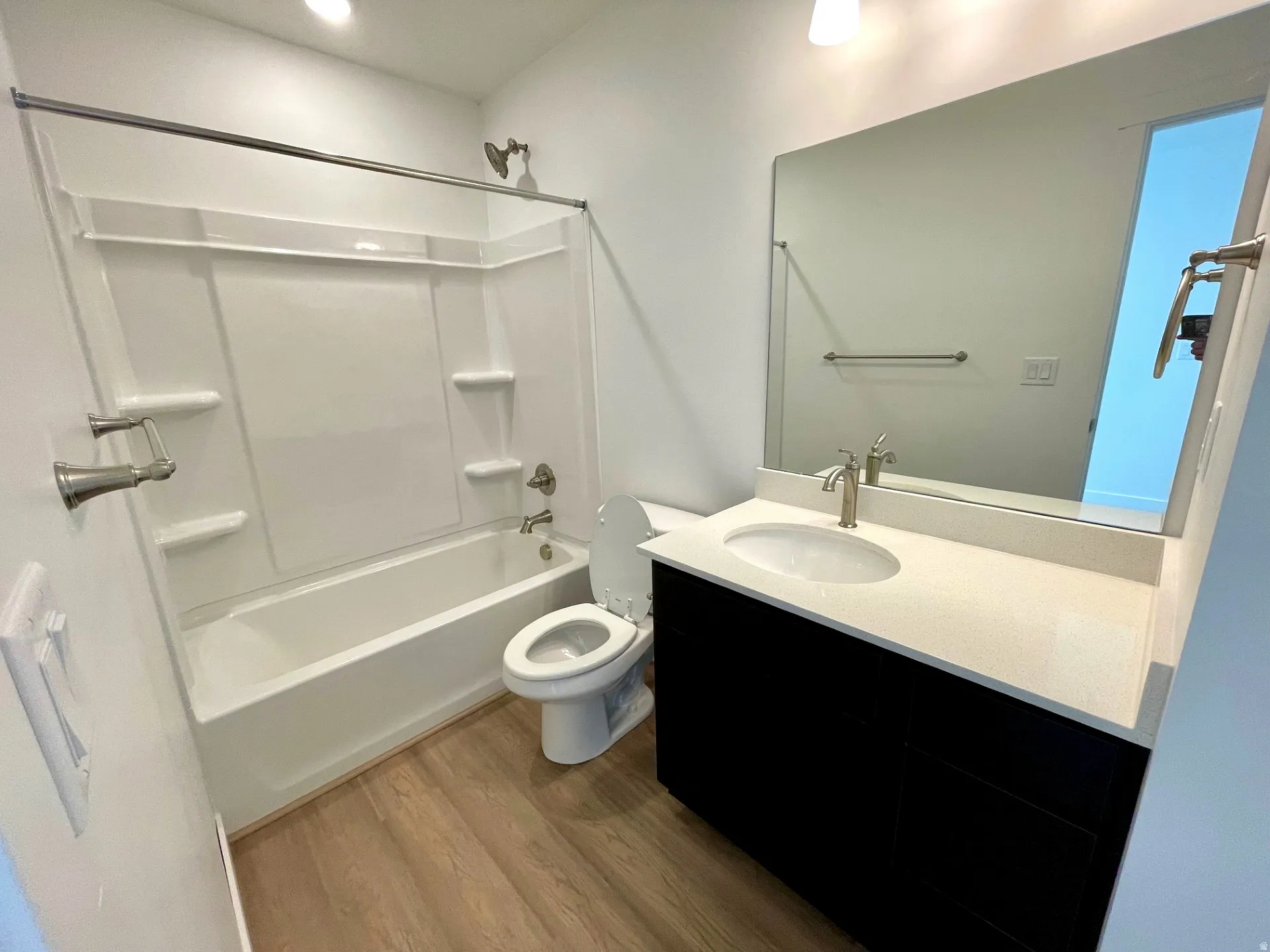 Bathroom featuring vanity, dark wood-style flooring, and tub / shower combination