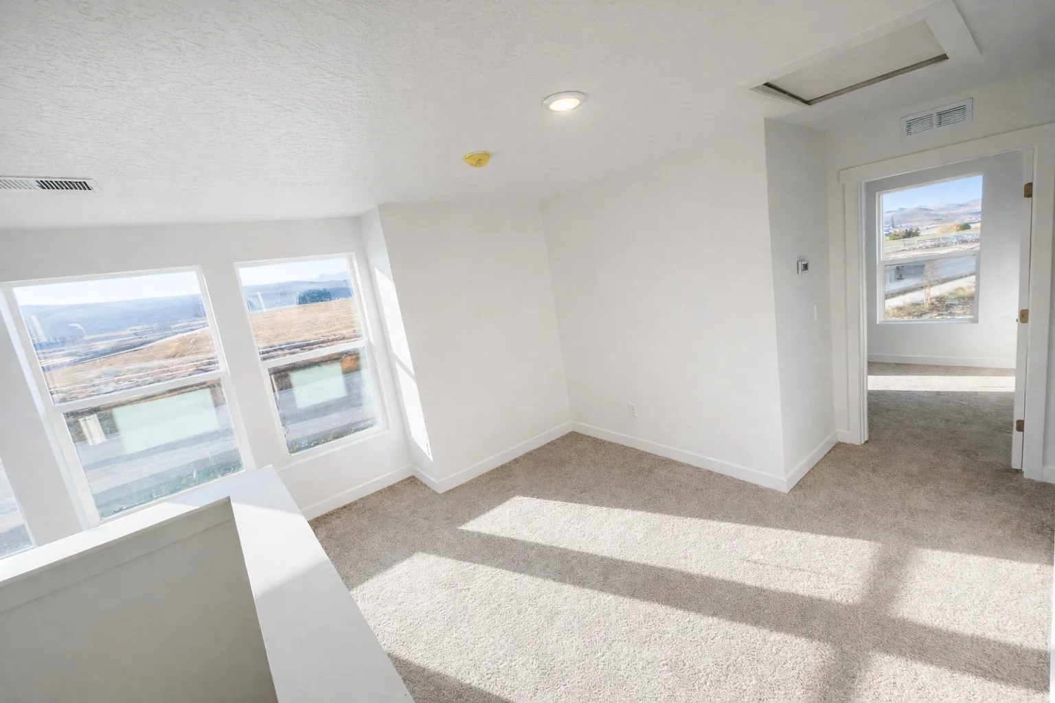 Spare room with light carpet, a textured ceiling, and recessed lighting