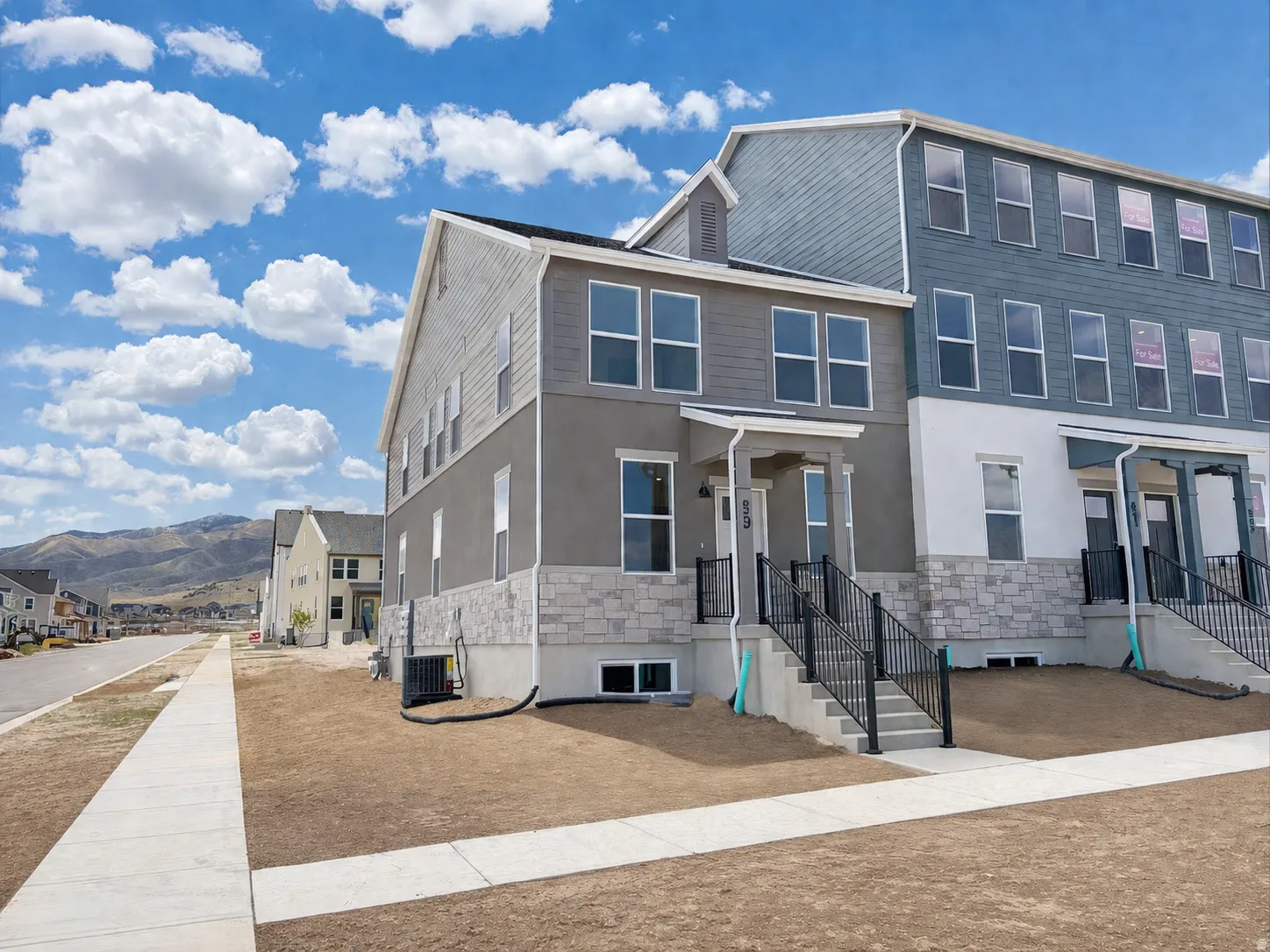 View of front of home featuring stone siding, a mountain view, and stucco siding