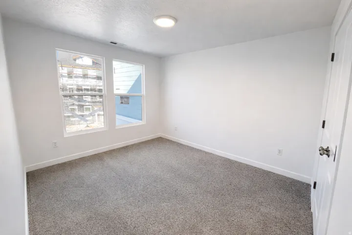 Carpeted empty room with baseboards and a textured ceiling