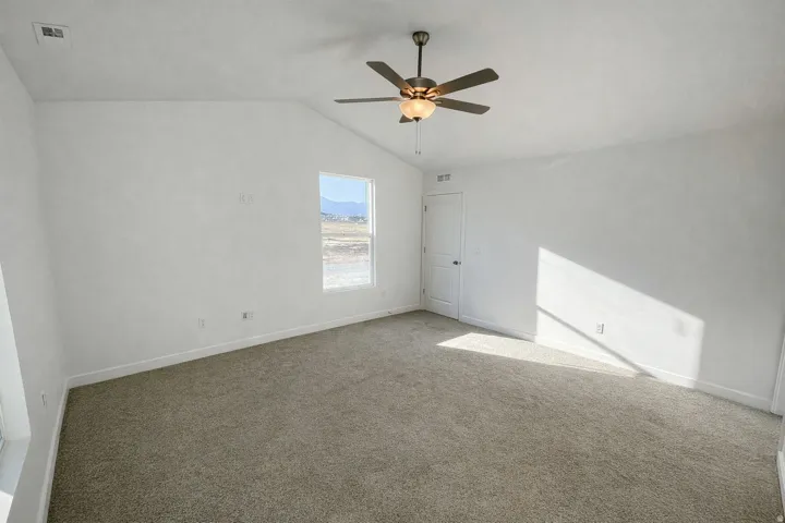 Empty room featuring carpet and ceiling fan