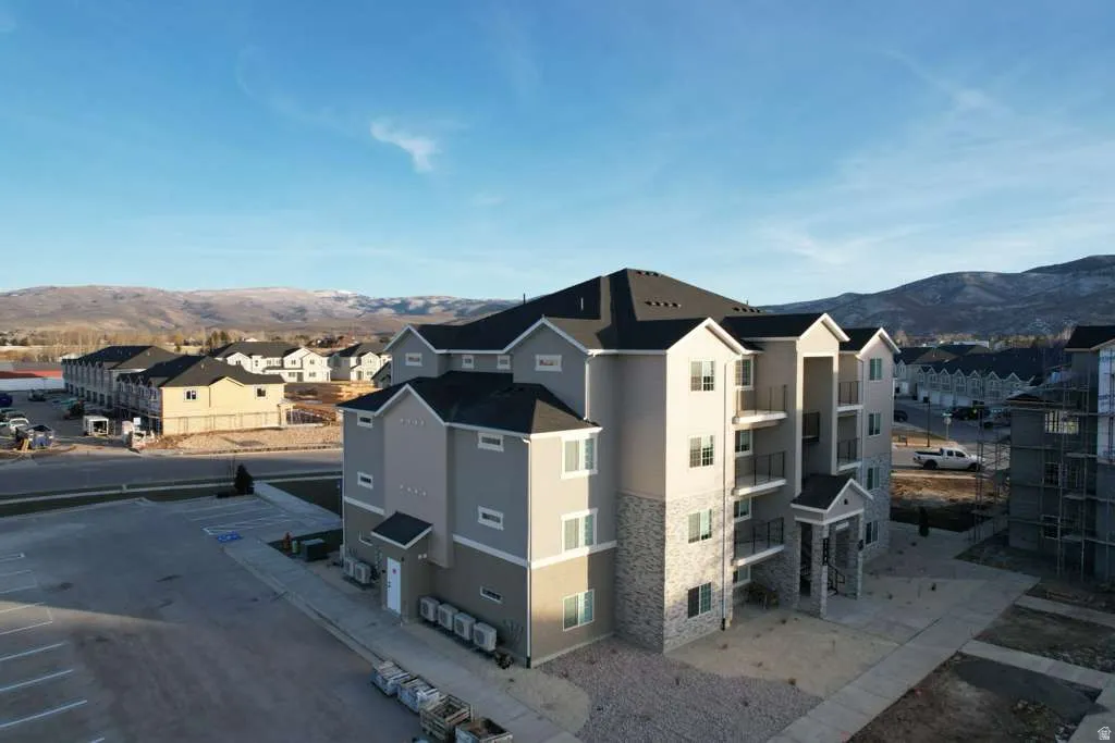 View of home's exterior featuring a mountain view, stucco siding, stone siding, and a patio