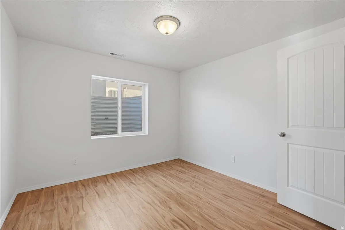 Empty room with light wood-type flooring and baseboards