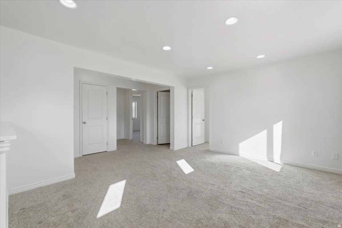 Empty room with recessed lighting and light colored carpet