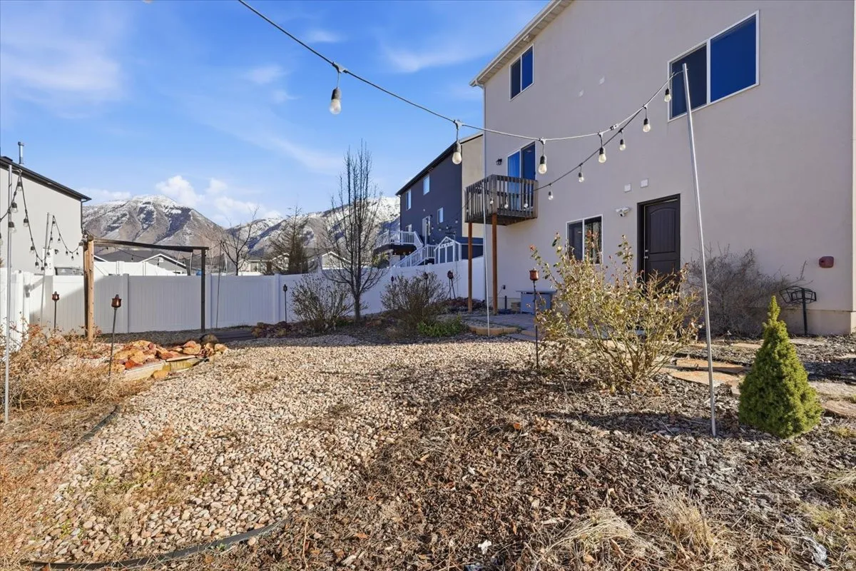 Fenced backyard featuring a mountain view, a patio, and a balcony