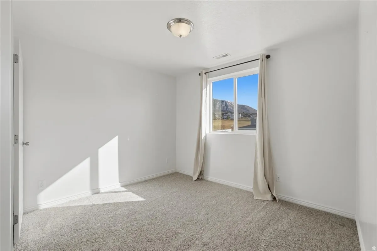 Empty room with light carpet and a mountain view